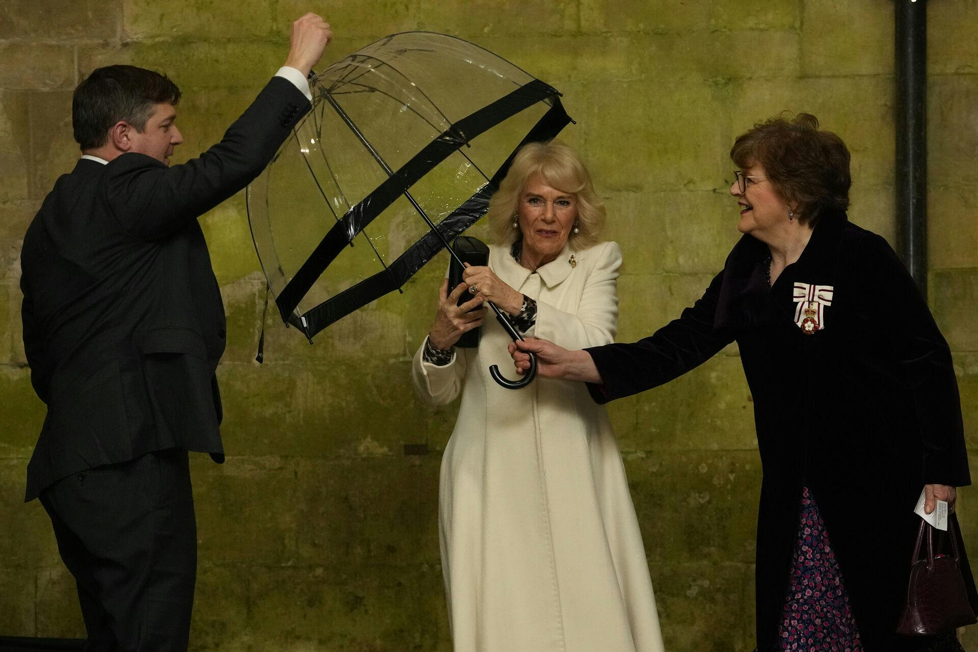 Queen Camilla hands her umbrella to an aide as she arrives to attend a musical evening at Salisbury Cathedral in Wiltshire, to celebrate the work of local charities including the Wiltshire Bobby Van Trust, Wiltshire Air Ambulance, and Community First - Youth Action Wiltshire, as well as the regimental charities of the Grenadier Guards and The Rifles. Picture date: Thursday February 8, 2024.