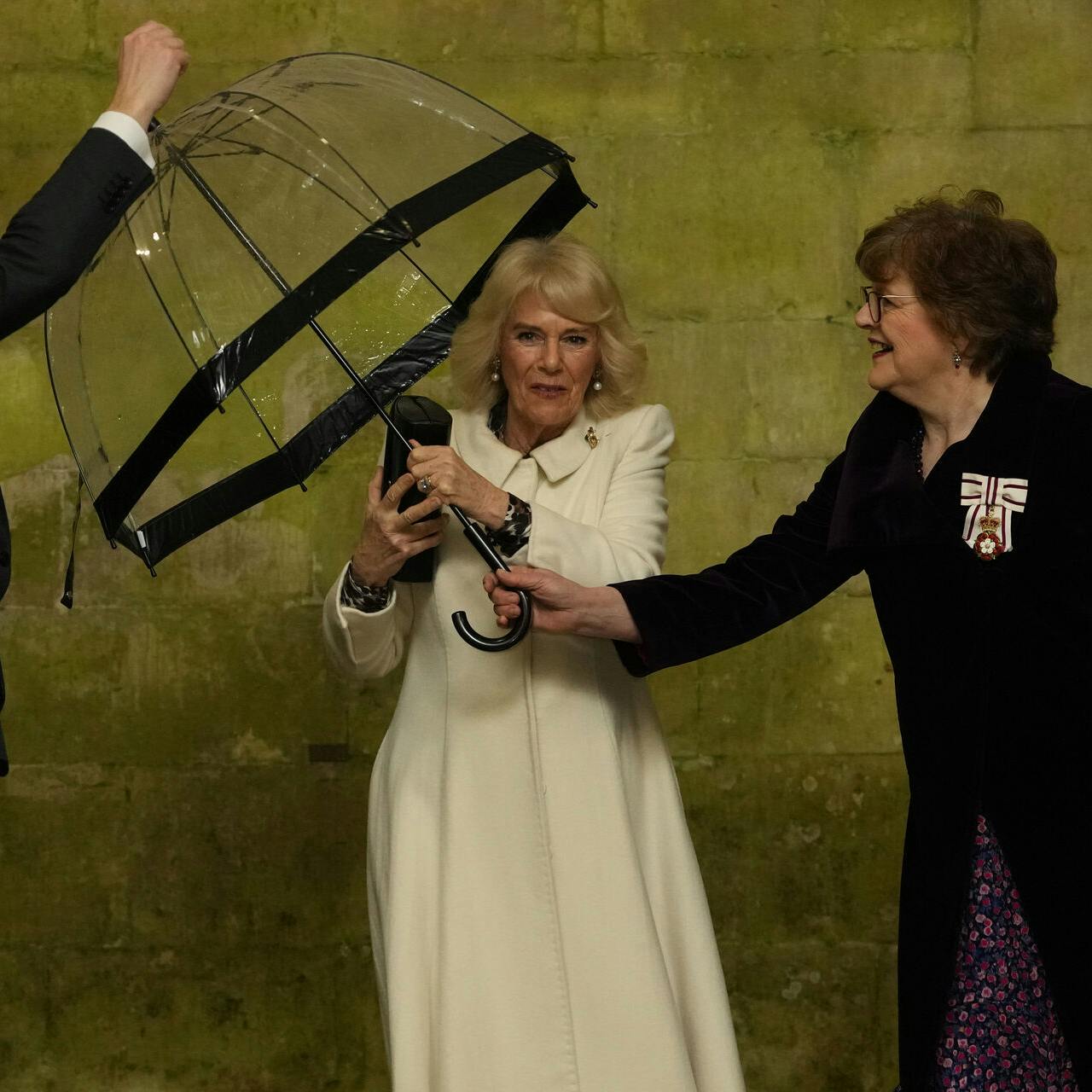 Queen Camilla hands her umbrella to an aide as she arrives to attend a musical evening at Salisbury Cathedral in Wiltshire, to celebrate the work of local charities including the Wiltshire Bobby Van Trust, Wiltshire Air Ambulance, and Community First - Youth Action Wiltshire, as well as the regimental charities of the Grenadier Guards and The Rifles. Picture date: Thursday February 8, 2024.