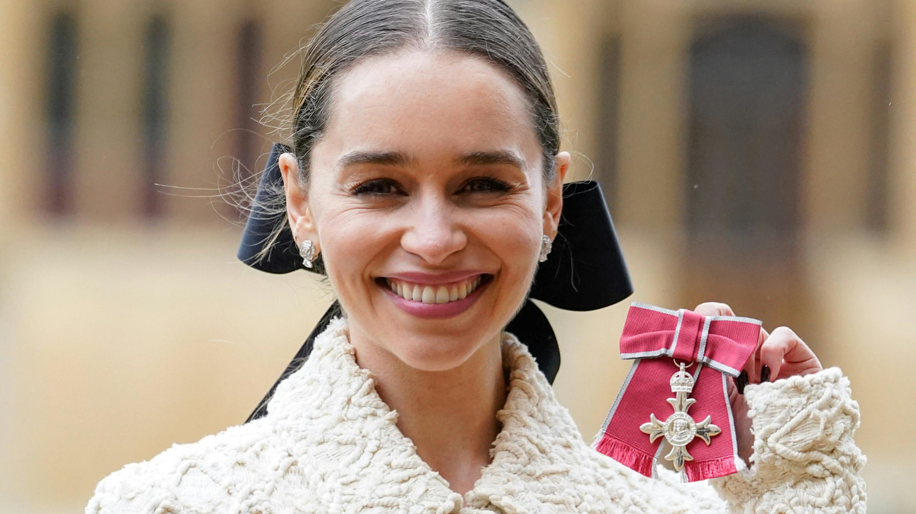 En stolt og glad Emilia Clarke viser sin orden frem. Nu kan hun kalde sig Member of the British Empire. 