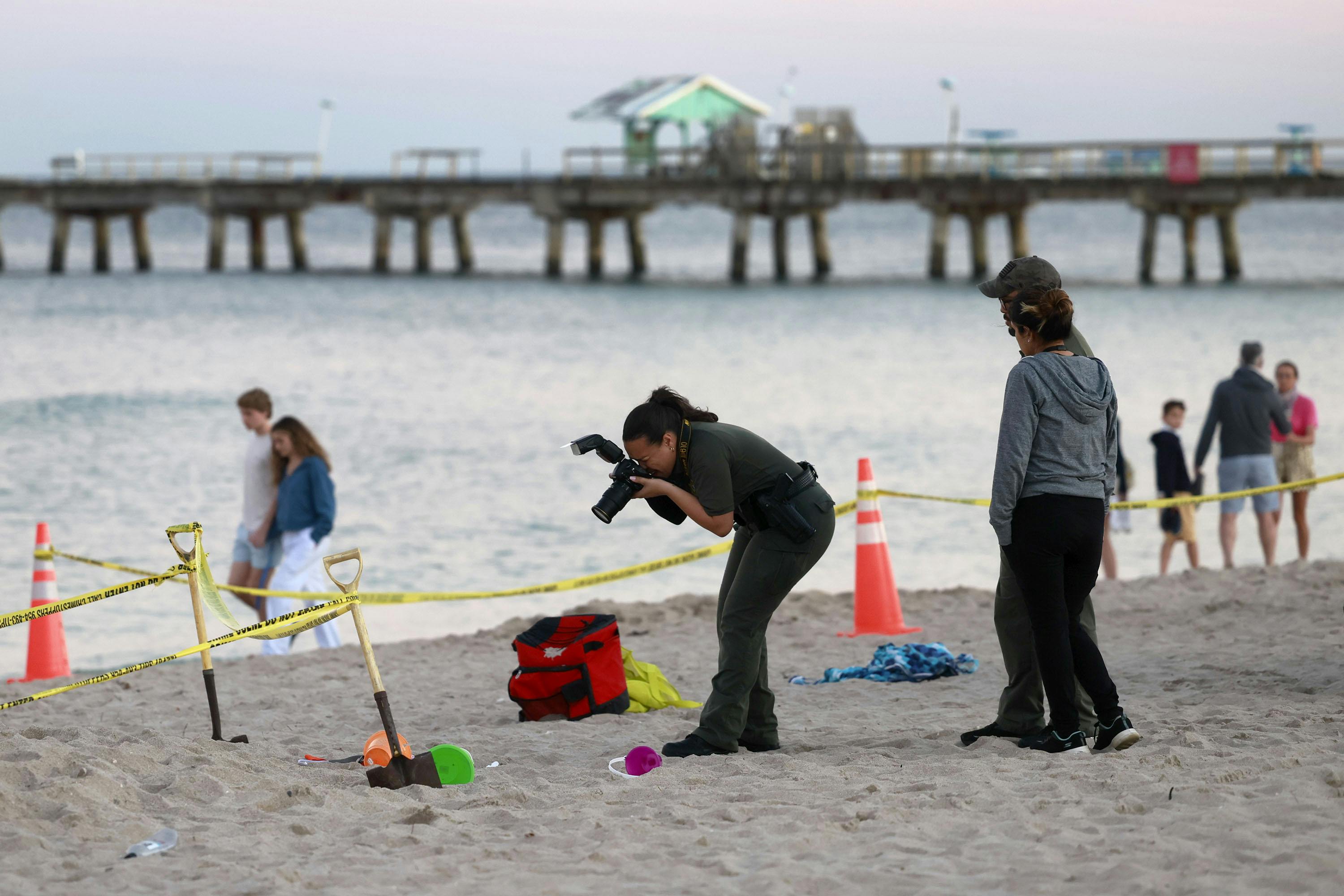 February 21, 2024, Lauderdale-By-The-Sea, FL, USA: Investigators on the beach in Lauderdale-by-the-Sea take photos of the scene of a sand collapse on Tuesday, Feb. 20, 2024. A young girl died Tuesday afternoon after she and a young boy were digging a hole in the sand on the beach at Lauderdale-by-the-Sea when it collapsed on them, burying them both, a city official said. (Credit Image: © Mike Stocker/South Florida Sun-Sentinel via ZUMA Press Wire)