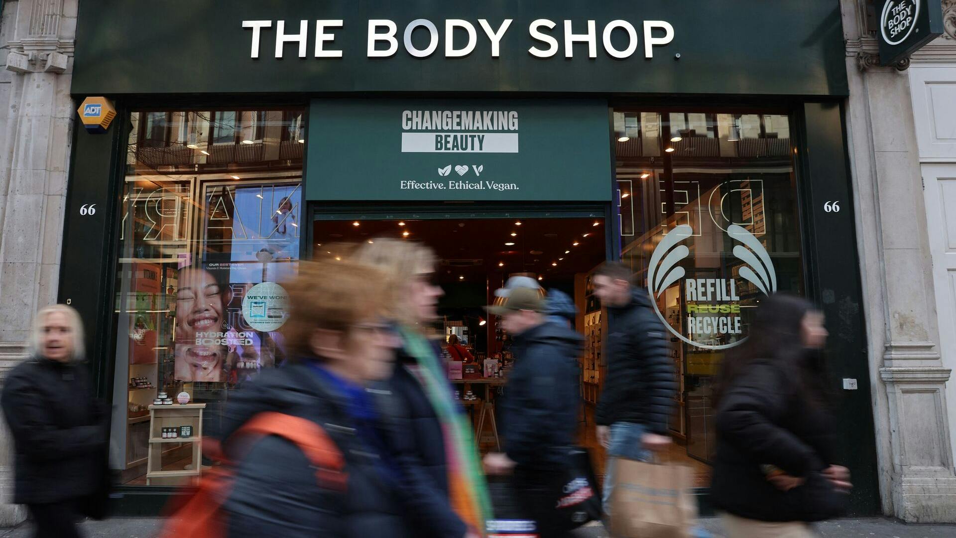 Pedestrians walk bas a branch of The Body Shop in central London on February 12, 2024. The Body Shop, the near 50-year-old cosmetics company renowned for its ethical hair and skin products, is near bankrupt in the UK after poor Christmas trade, according to reports in British media. (Photo by Daniel LEAL / AFP)