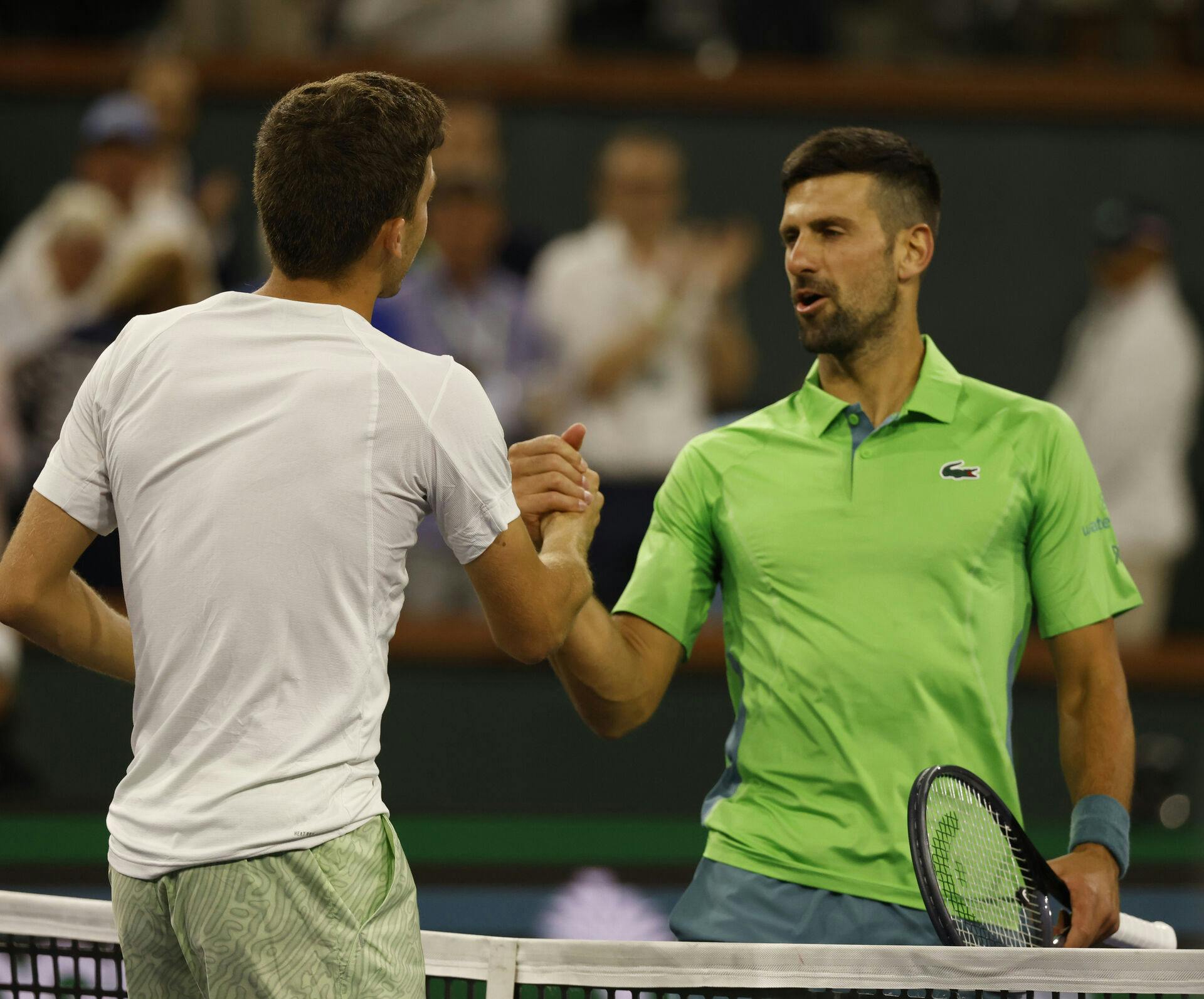 Luca Nardi bliver her lykønsket af Novak Djokovic efter den overraskende sejr.