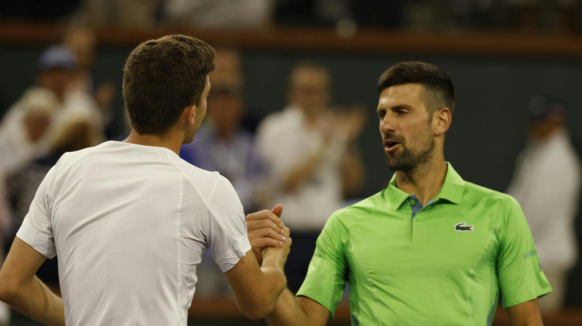 Luca Nardi bliver her lykønsket af Novak Djokovic efter den overraskende sejr.