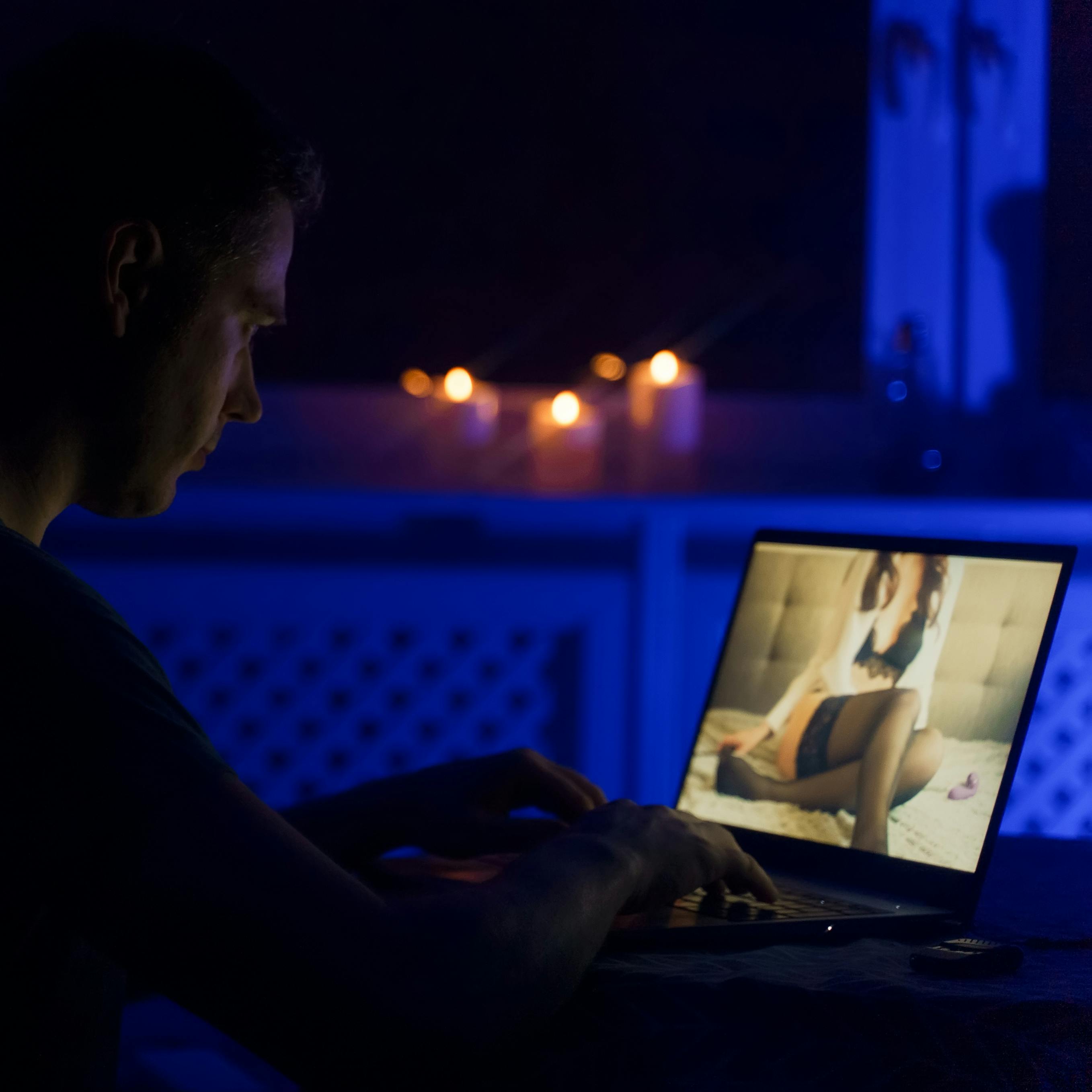 Man chatting with webcam model late at night.