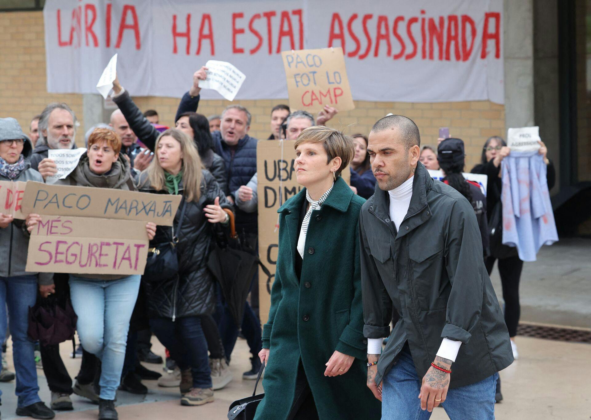 Der var protester foran fængslet, hvor Dani Alves ses sammen med sin advokat, Ines Guardiola.