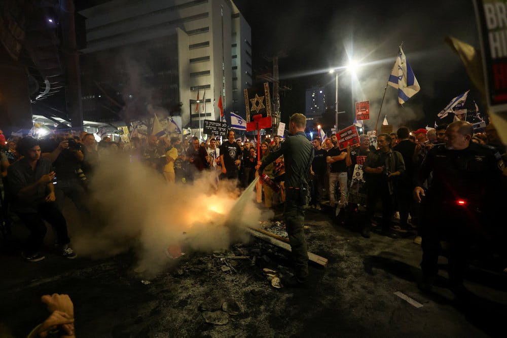 Politibetjent med en brandslukker til demonstration mod Benjamin Netanyahu lørdag.