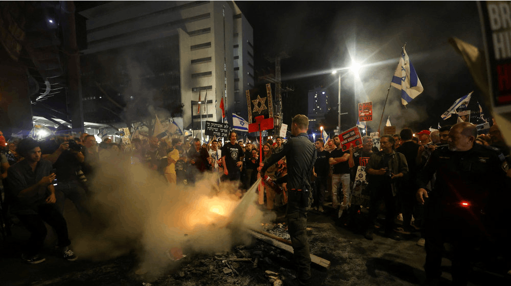 Politibetjent med en brandslukker til demonstration mod Benjamin Netanyahu lørdag.
