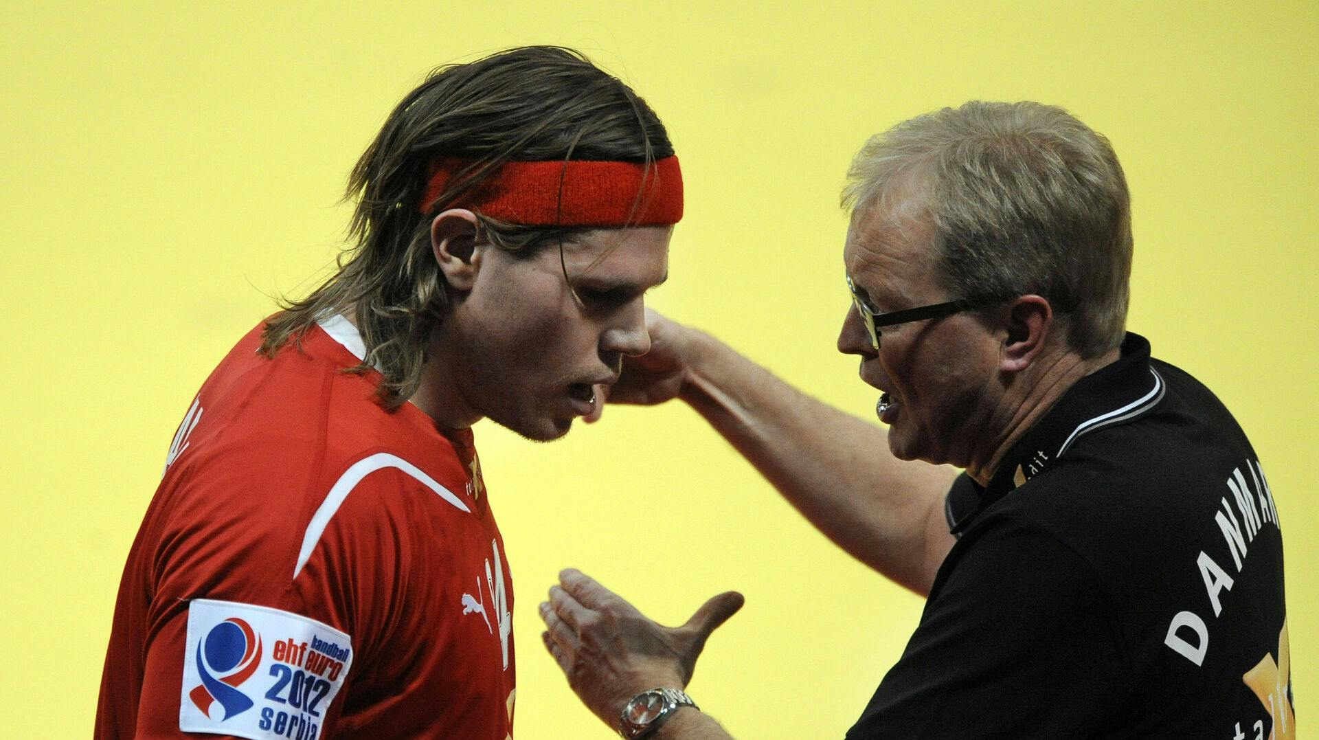 Denmark's coach Ulrik Wilbek (R) talks to his player Mikkel Hansen (L) during the Men's EHF Euro 2012 Handball Championship match Denmark vs Macedonia on January 21, 2012 at the Belgrade Arena. Denmark won 33-32. AFP PHOTO / ATTILA KISBENEDEK