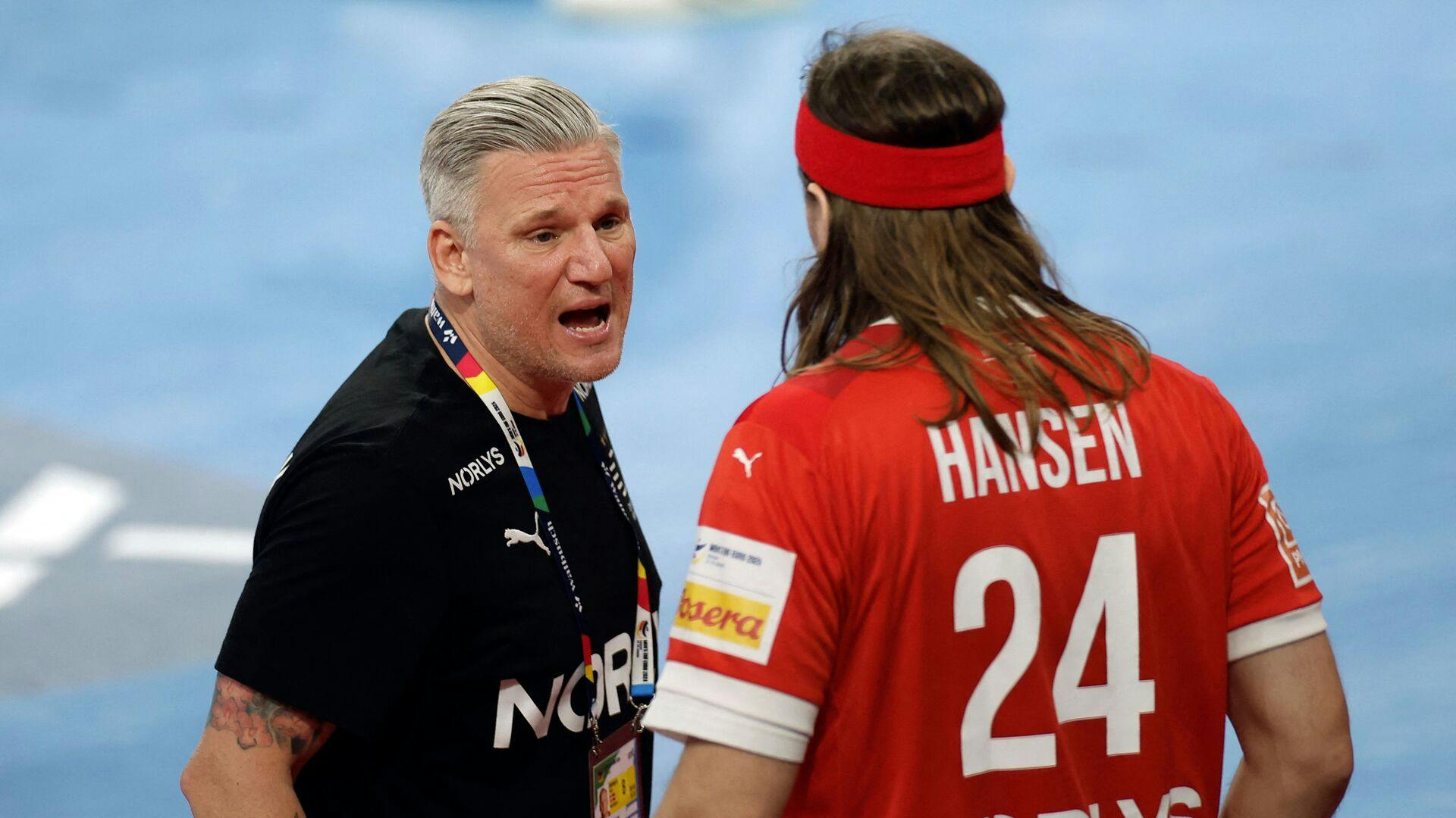 Denmark's coach Nikolaj Jacobsen (L) speaks with Denmark's left back #24 Mikkel Hansen during the Men's EURO 2024 EHF Handball European Championship main round match between Denmark and Sweden in Hamburg, northern Germany on January 19, 2024. (Photo by Odd ANDERSEN / AFP)