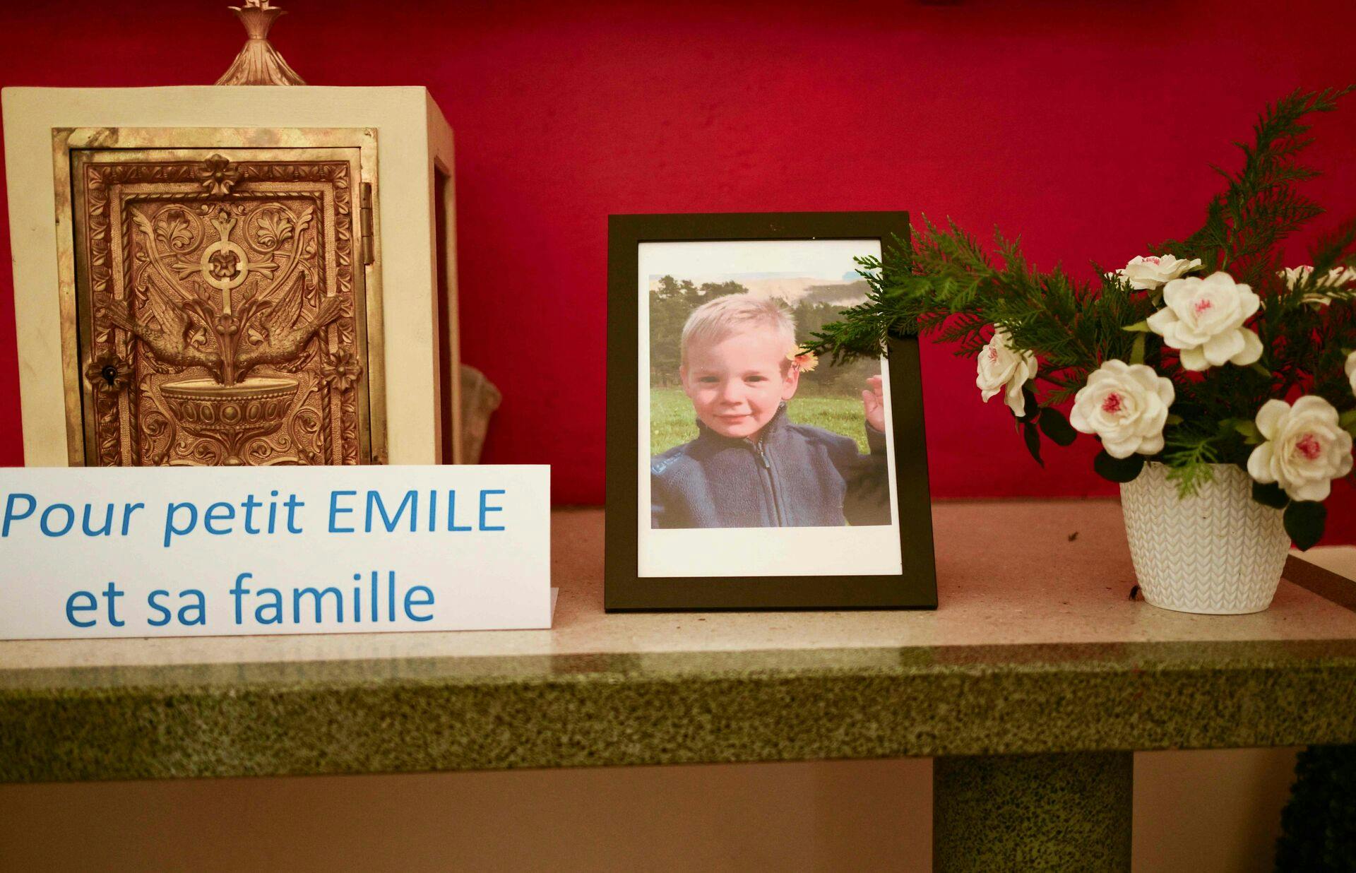 (FILES) This photograph taken on March 21, 2024, inside a chapel in La Bouilladisse southern France, shows a card with the inscription reading "For the little Emile and his family" next to a portrait of Emile, a missing boy, who disappeared on July 8, 2023 in Le Vernet, southeastern France. Two-and-a-half-year-old Emile's bones were found in the Haut-Vernet hamlet, the public prosecutor's office, announced on March 31, 2024. (Photo by CHRISTOPHE SIMON / AFP)