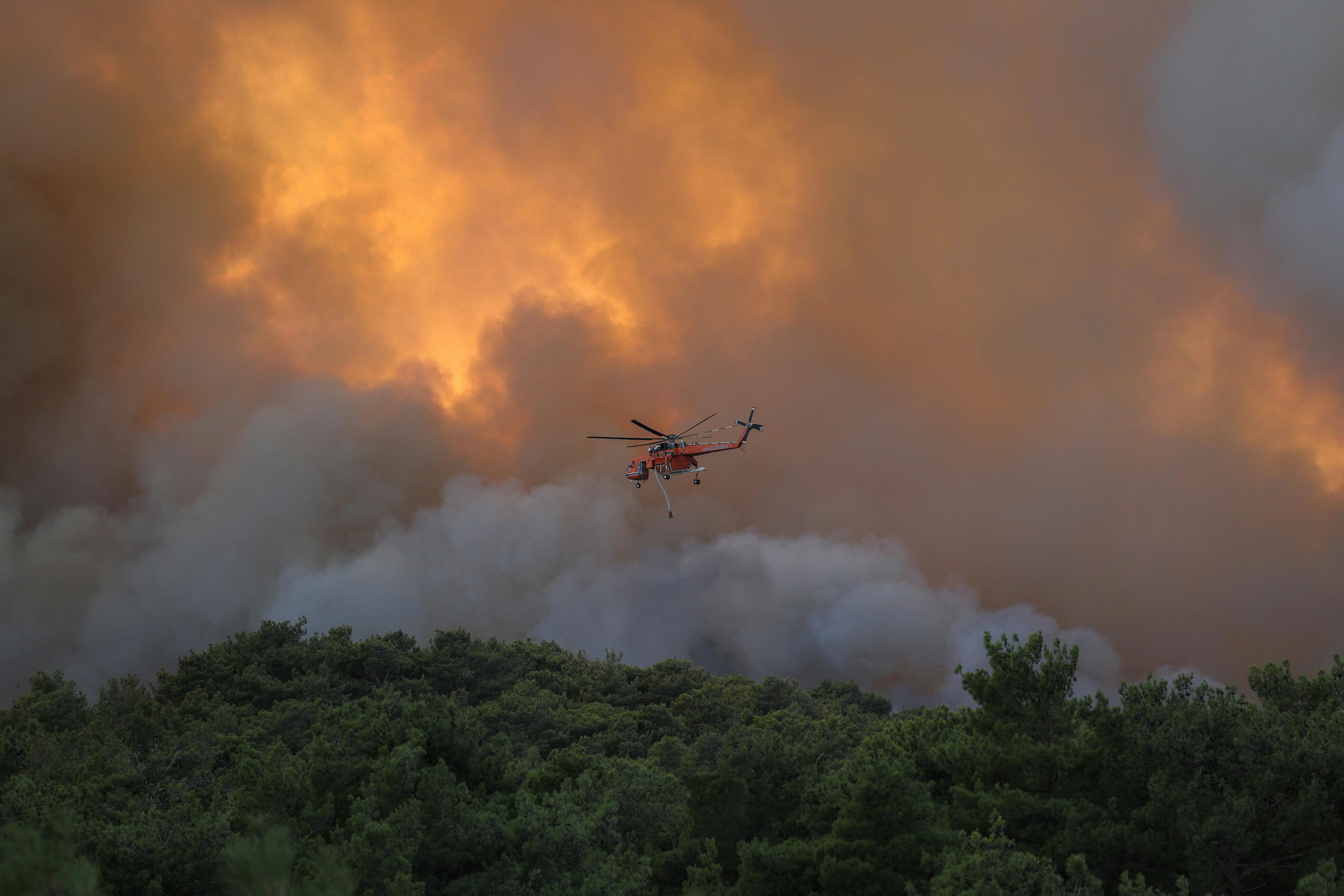 A firefighting helicopter flies over a wildfire burning near the village of Provatonas in the region of Evros, Greece, September 2, 2023. REUTERS/Alexandros Avramidis
