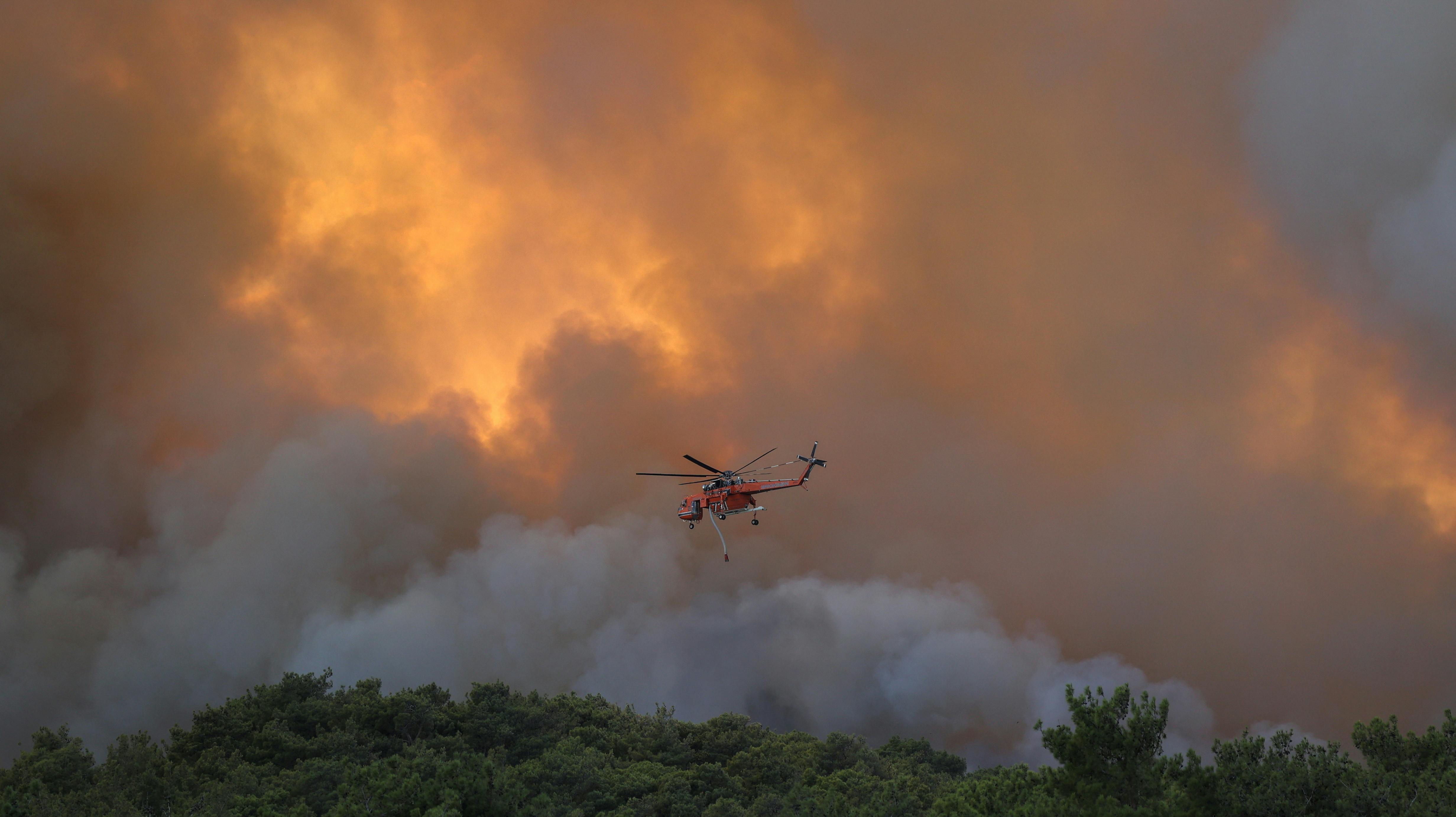 A firefighting helicopter flies over a wildfire burning near the village of Provatonas in the region of Evros, Greece, September 2, 2023. REUTERS/Alexandros Avramidis