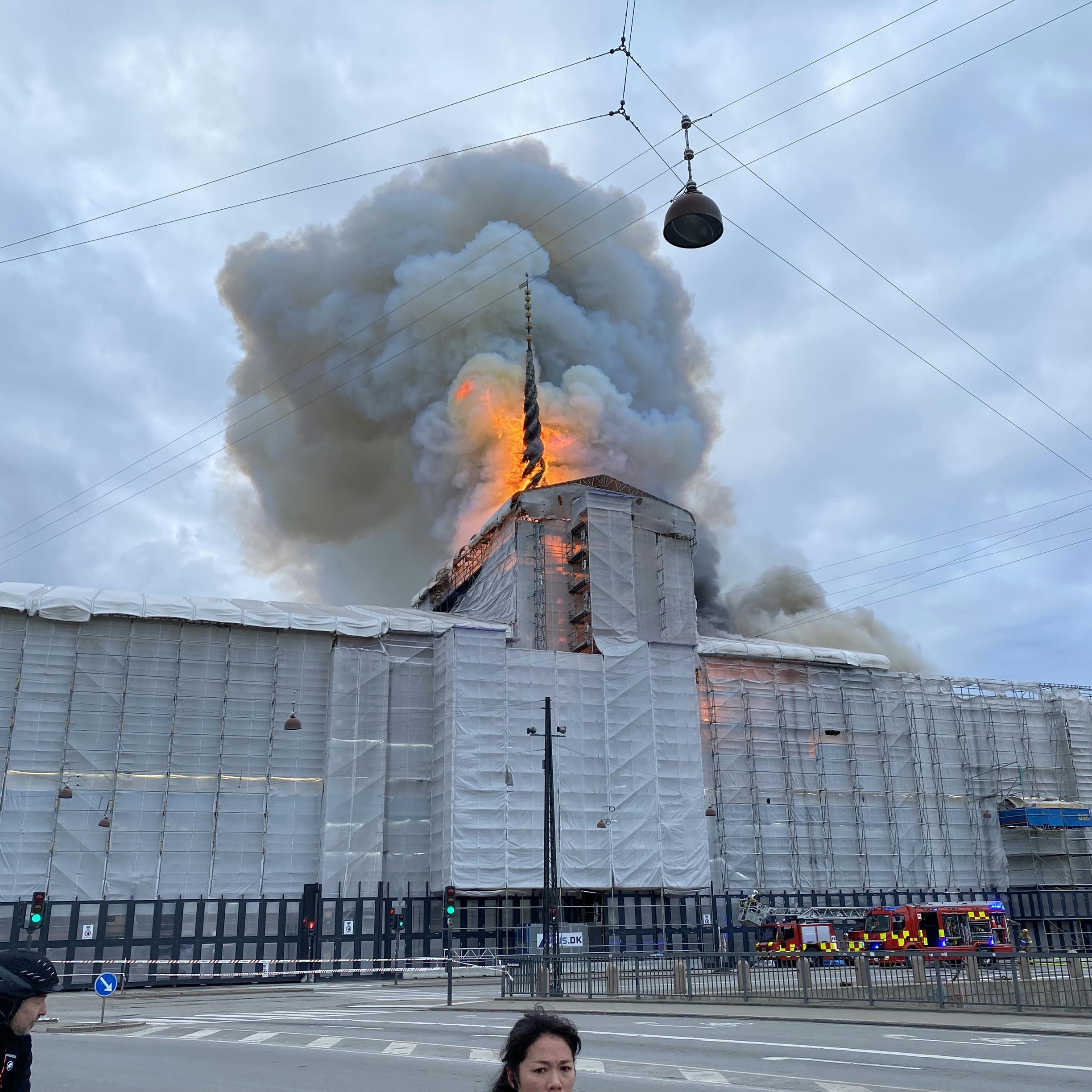 Flammer og en gigantisk røgsøjle står op over Børsen tirsdag formiddag.