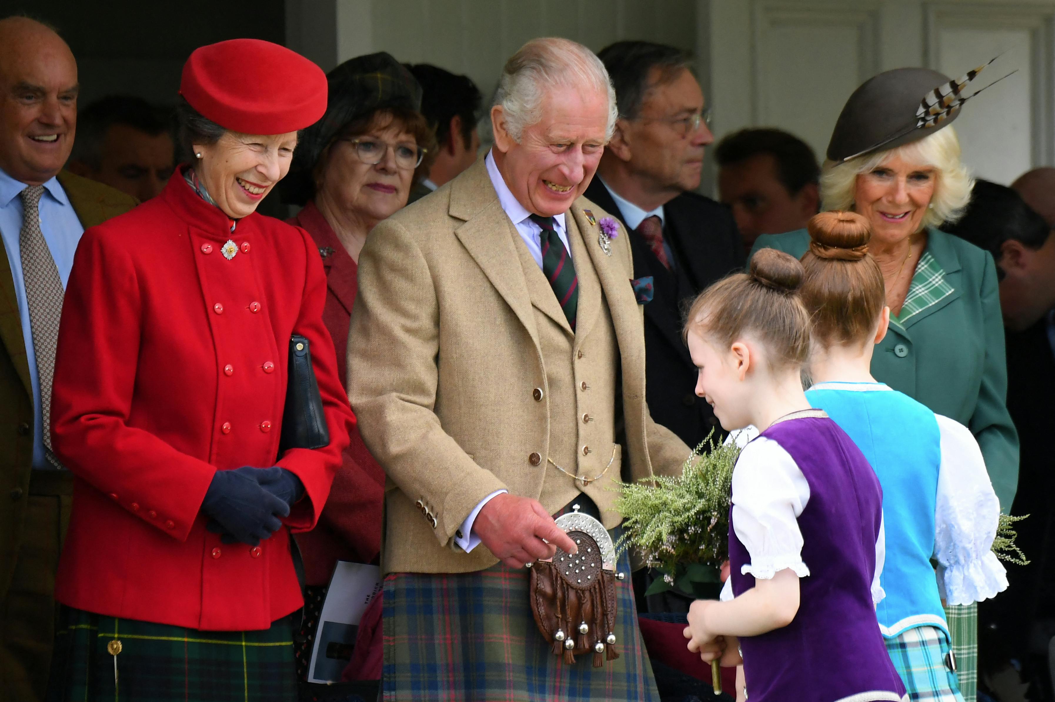 Prinsesse Anne, klædt i rødt, ses her med kong Charles og dronning Camilla. 