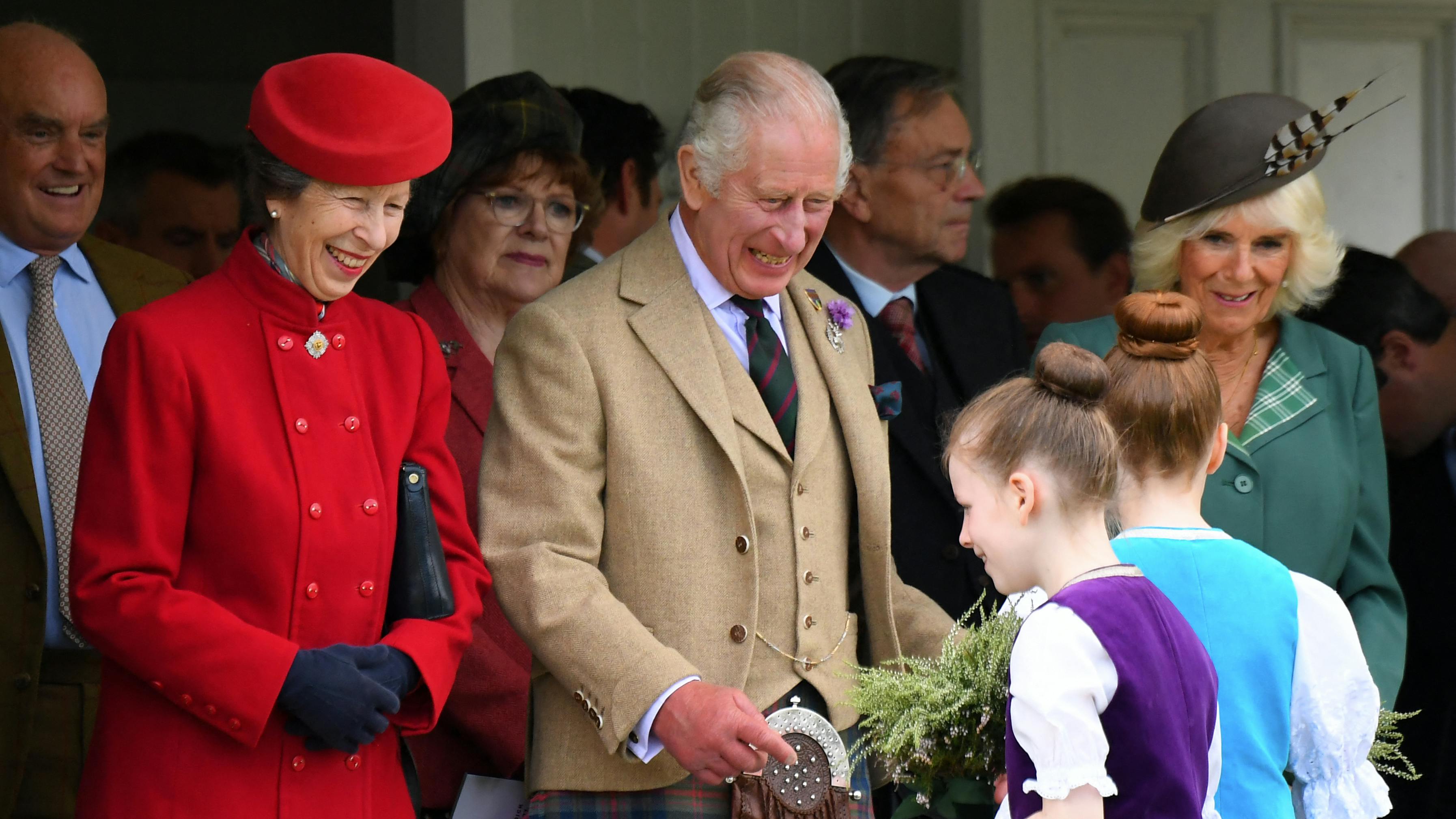 Prinsesse Anne, klædt i rødt, ses her med kong Charles og dronning Camilla. 