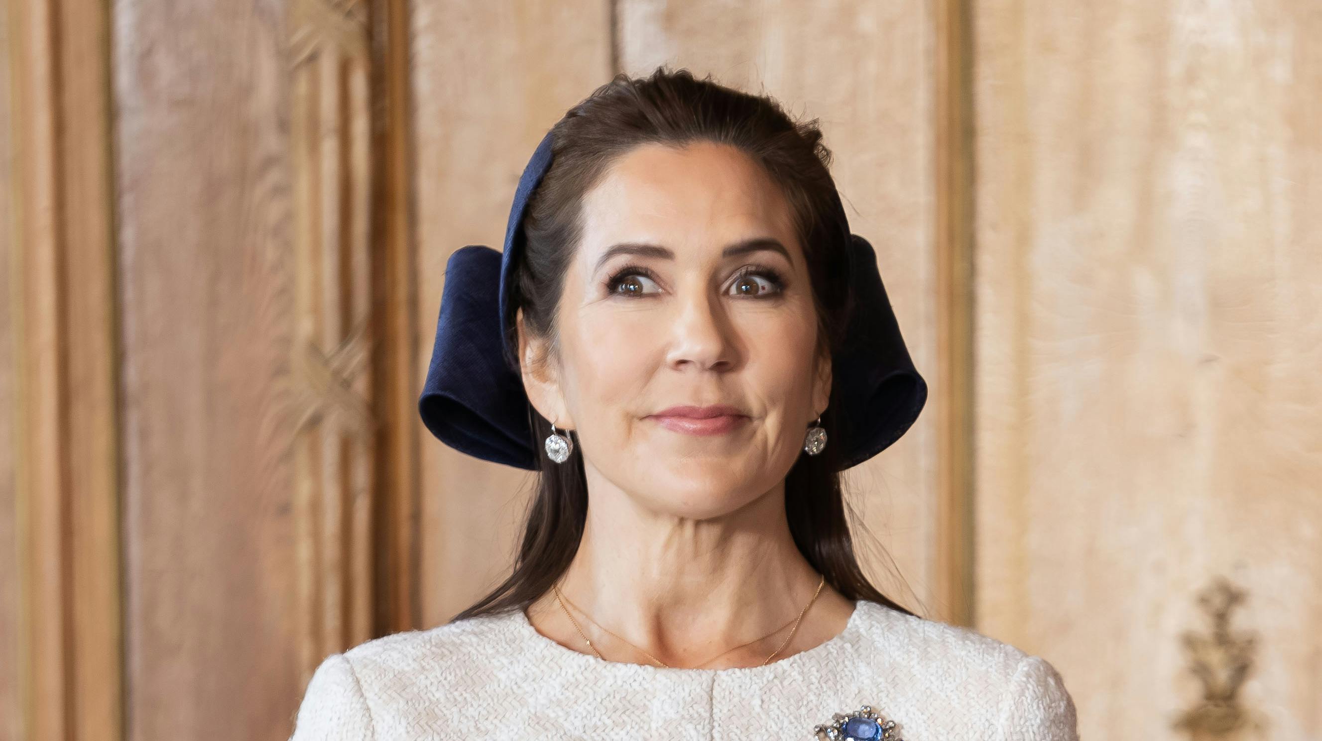 Dronning Mary står ved sin mands side, mens han holder tale i forbindelse med det svenske statsbesøg.