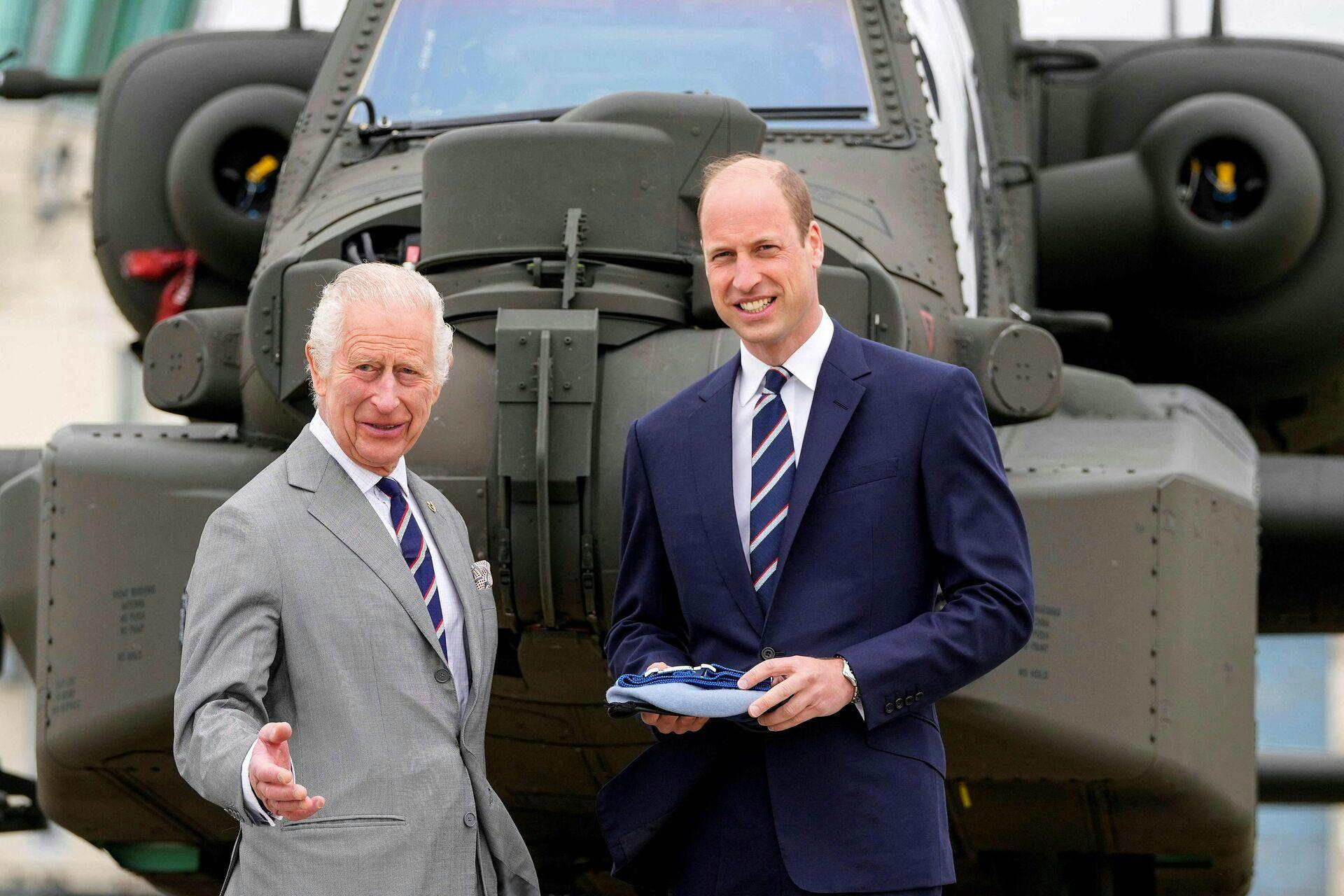 Britain's King Charles III officially hands over the role of Colonel-in-Chief of the Army Air Corps to Britain's Prince William, Prince of Wales in front of an Apache helicopter at the Army Aviation Centre in Middle Wallop, England, on May 13, 2024. (Photo by Kin Cheung / POOL / AFP)