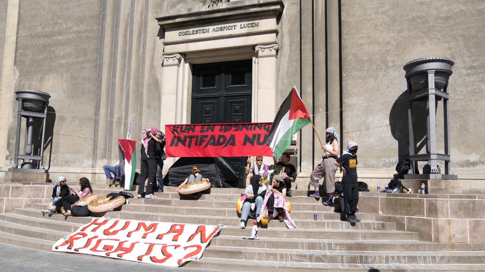 Hovedindgangen ved Københavns Universitets bygninger ved Frue Plads er blokeret af en række demonstranter. 