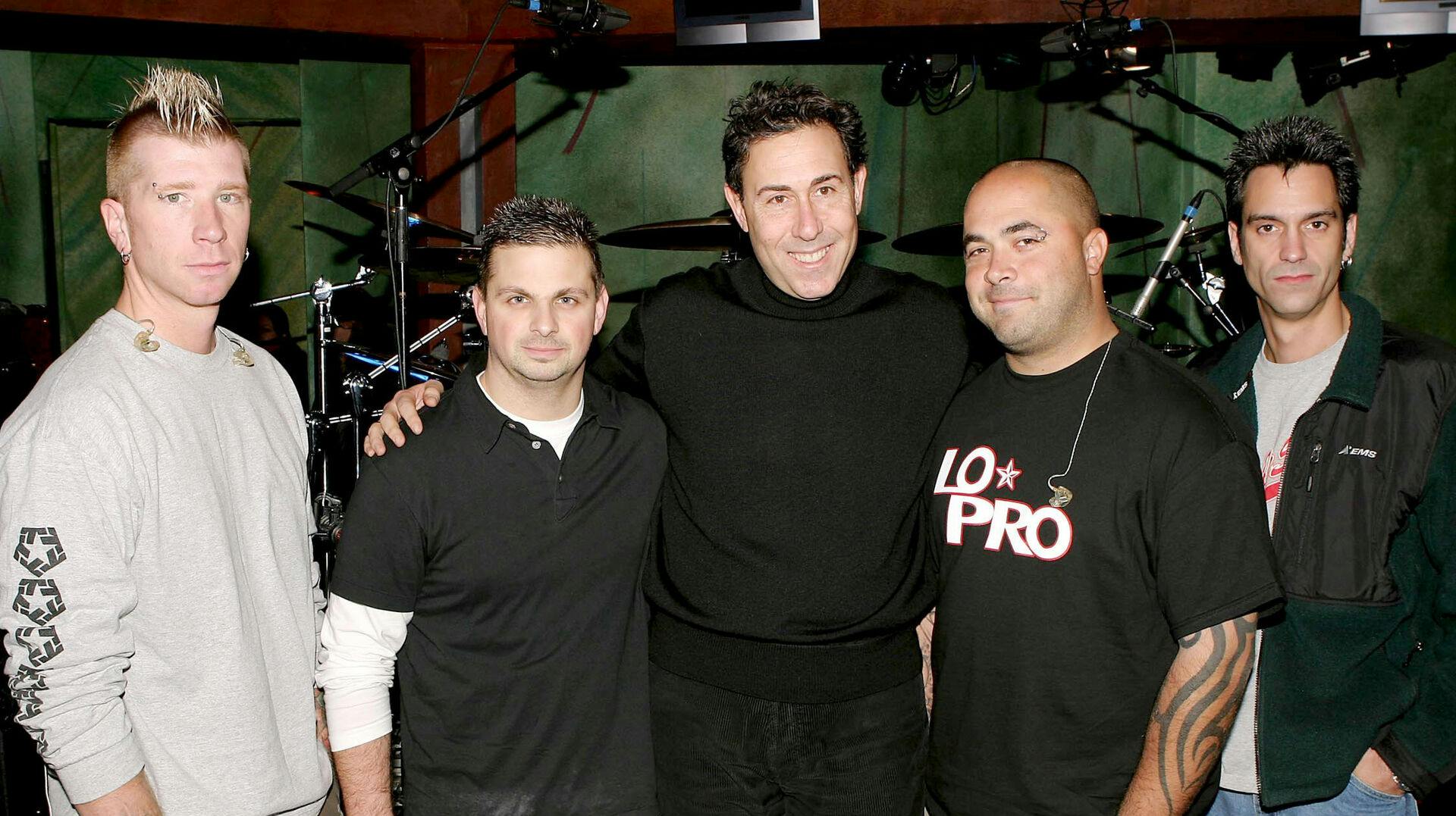 Jon Wysocki (yderst til venstre) sammen med de andre bandmedlemmer i Staind og en tv-vært (i midten), tilbage i 2003.