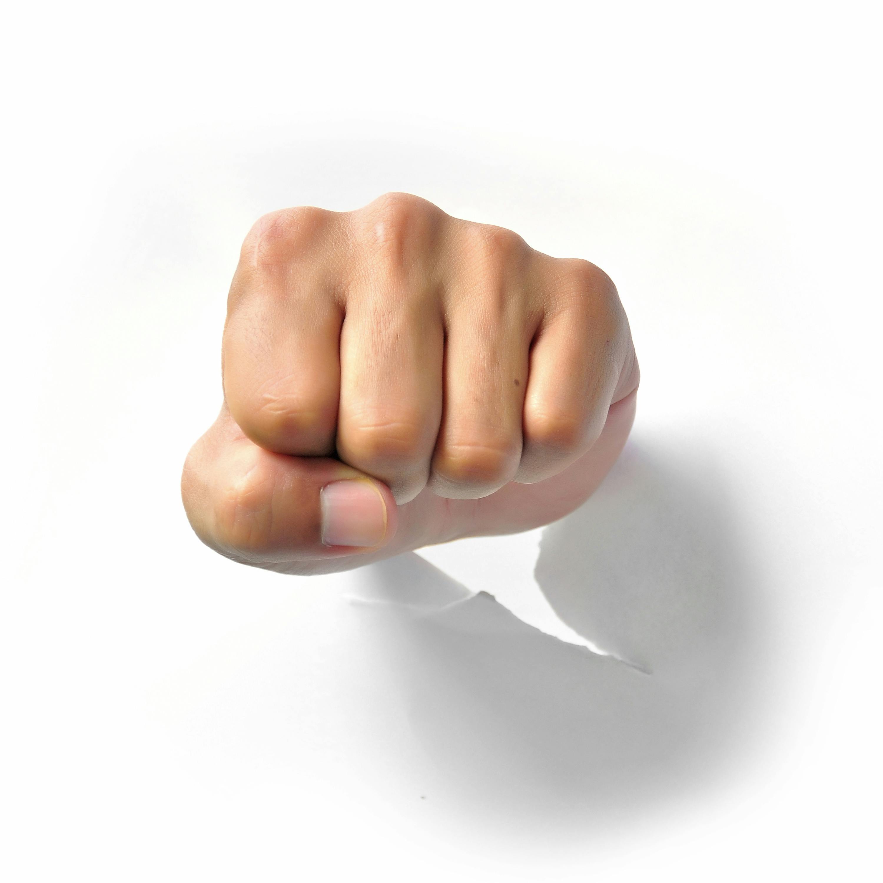 Fist punching paper isolated on white background