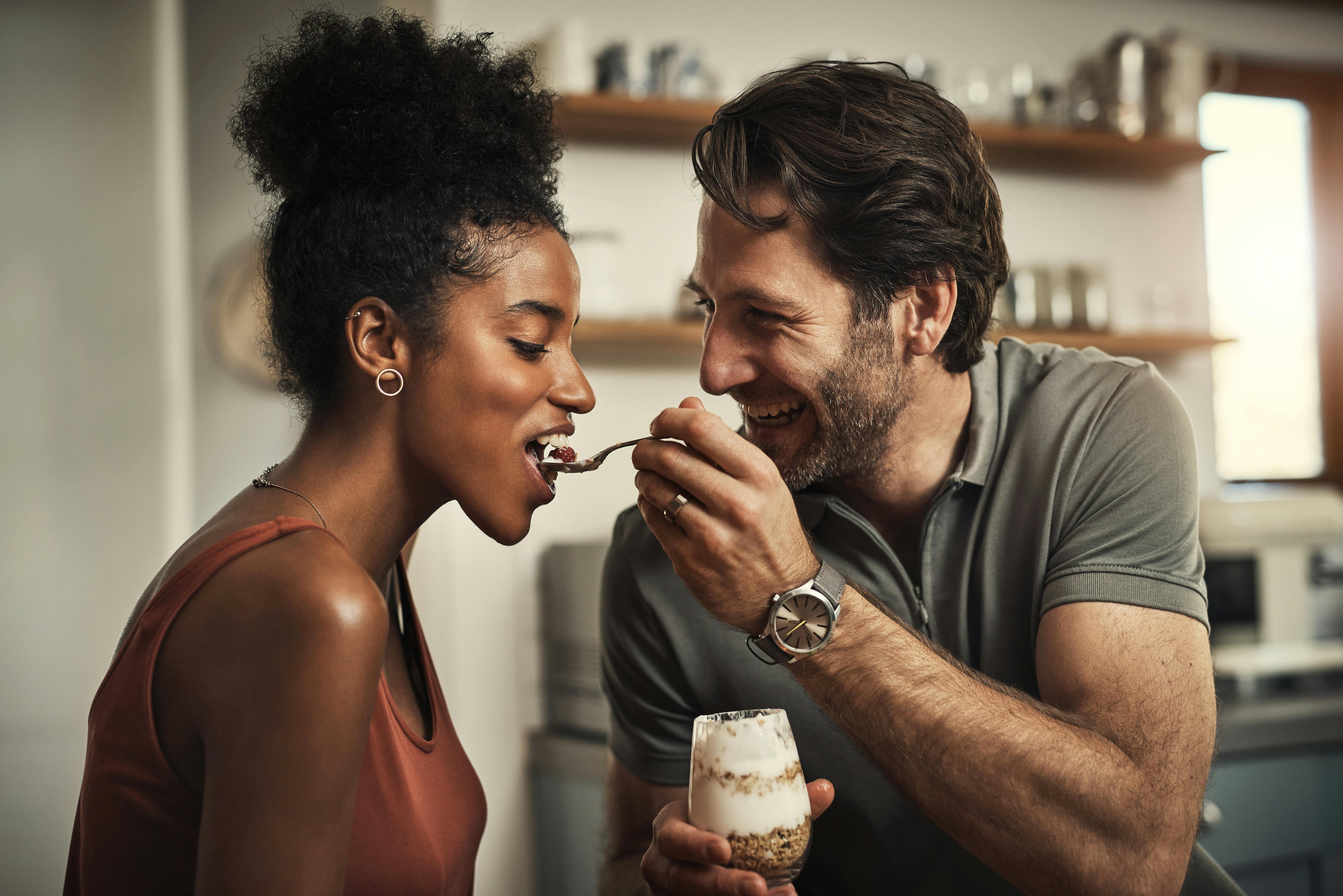 Cropped shot of an affectionate middle aged man feeding his wife dessert in their kitchen at home