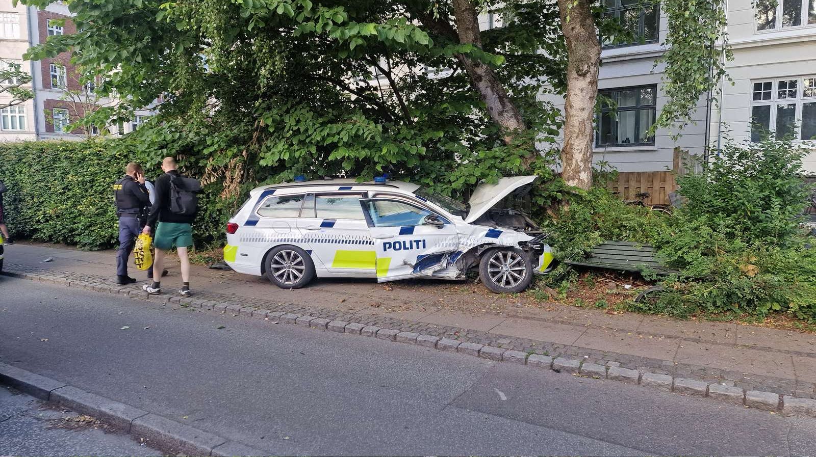 Politibilen skulle undvige en personbil, men endte i stedet i en bænk på fortovet. 