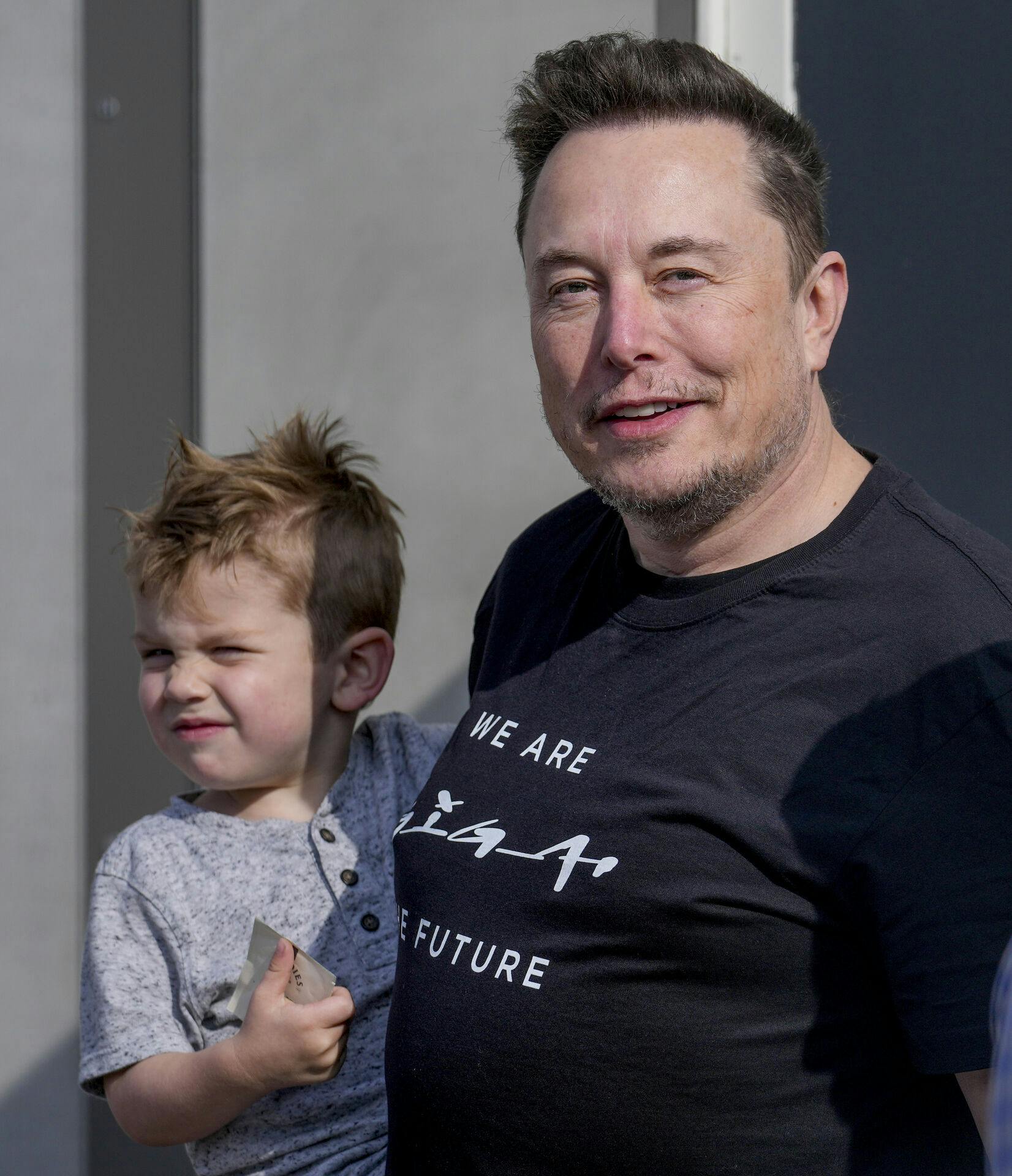 Elon Musk med et af sine efterhånden mange børn på armen.
