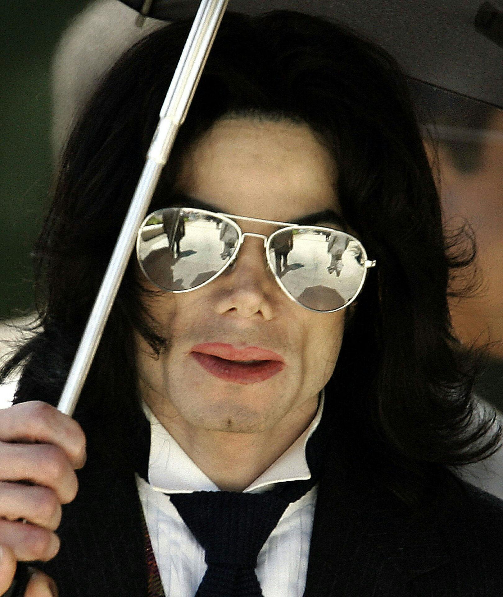 (FILES): This June 2, 2005 file photo shows Michael Jackson holding his umbrella as he leaves the Santa Barbara County courthouse in Santa Maria, California. Pop icon Michael Jackson died June 25, 2009 after suffering a cardiac arrest, the entertainment website TMZ.com reported. AFP PHOTO / Files / Timothy A. CLARY