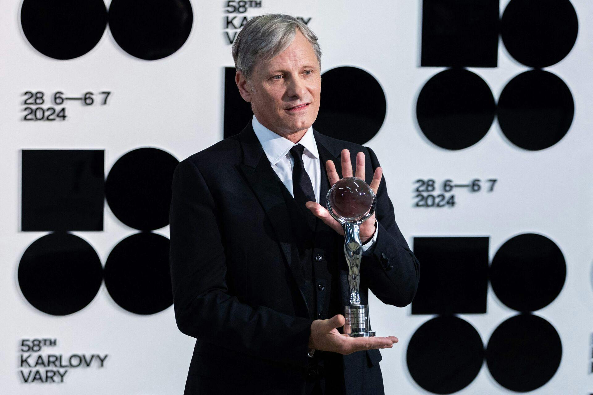 Viggo Mortensen poserer med den såkaldte Festival President's Award Crystal Globe, som han modtog fredag aften. 