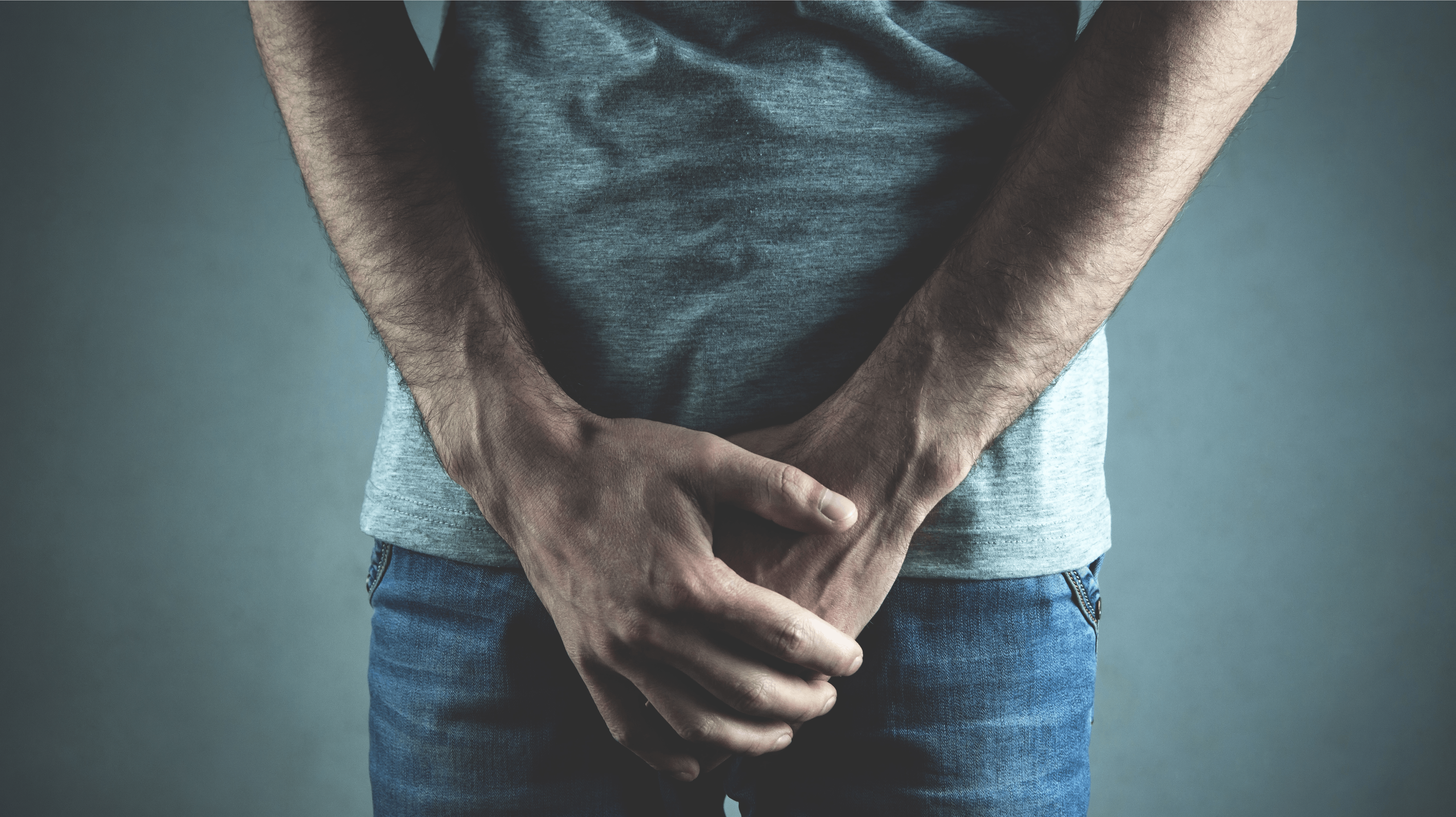 Caucasian man with hands holding his crotch. Inflammation of the prostate, erection problems