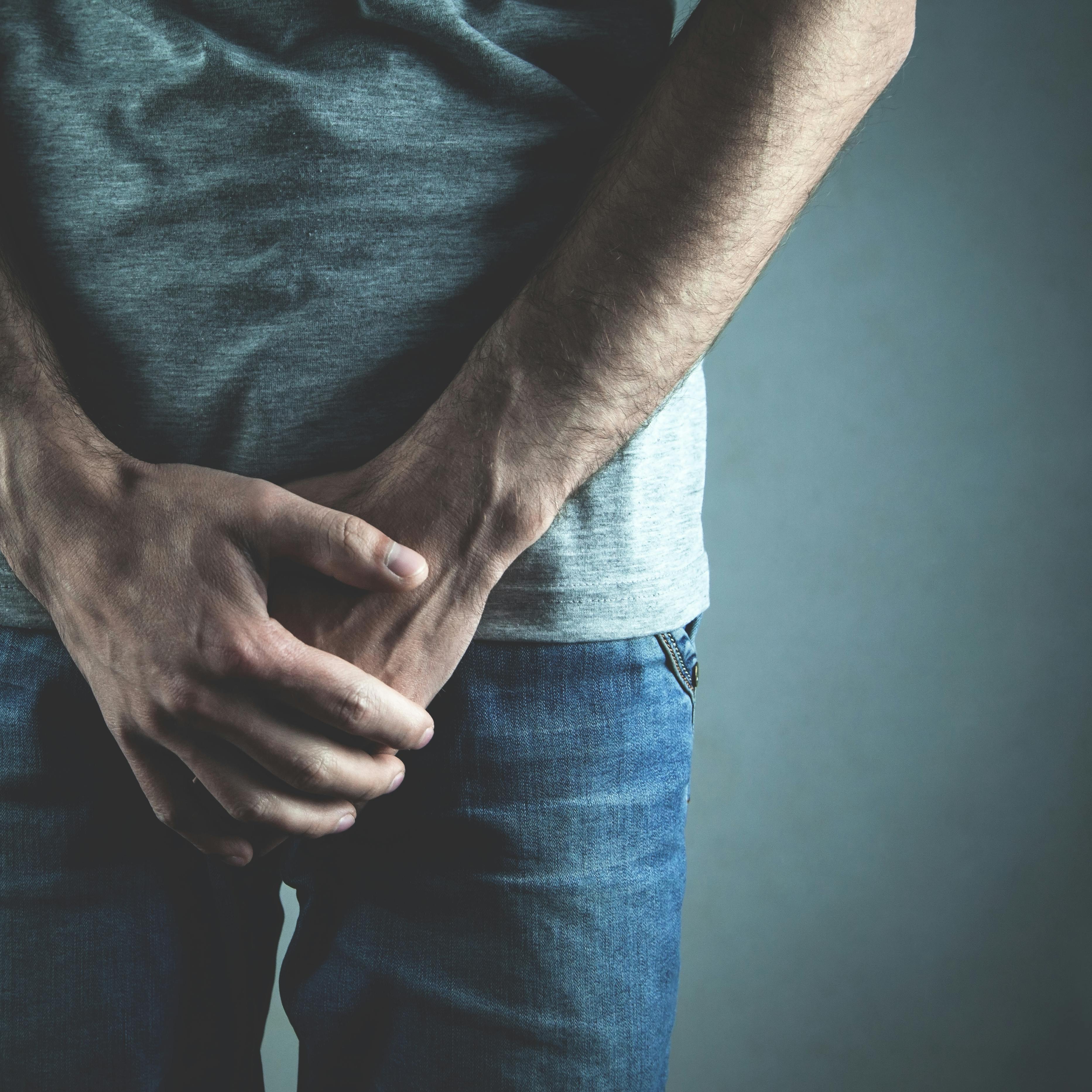 Caucasian man with hands holding his crotch. Inflammation of the prostate, erection problems