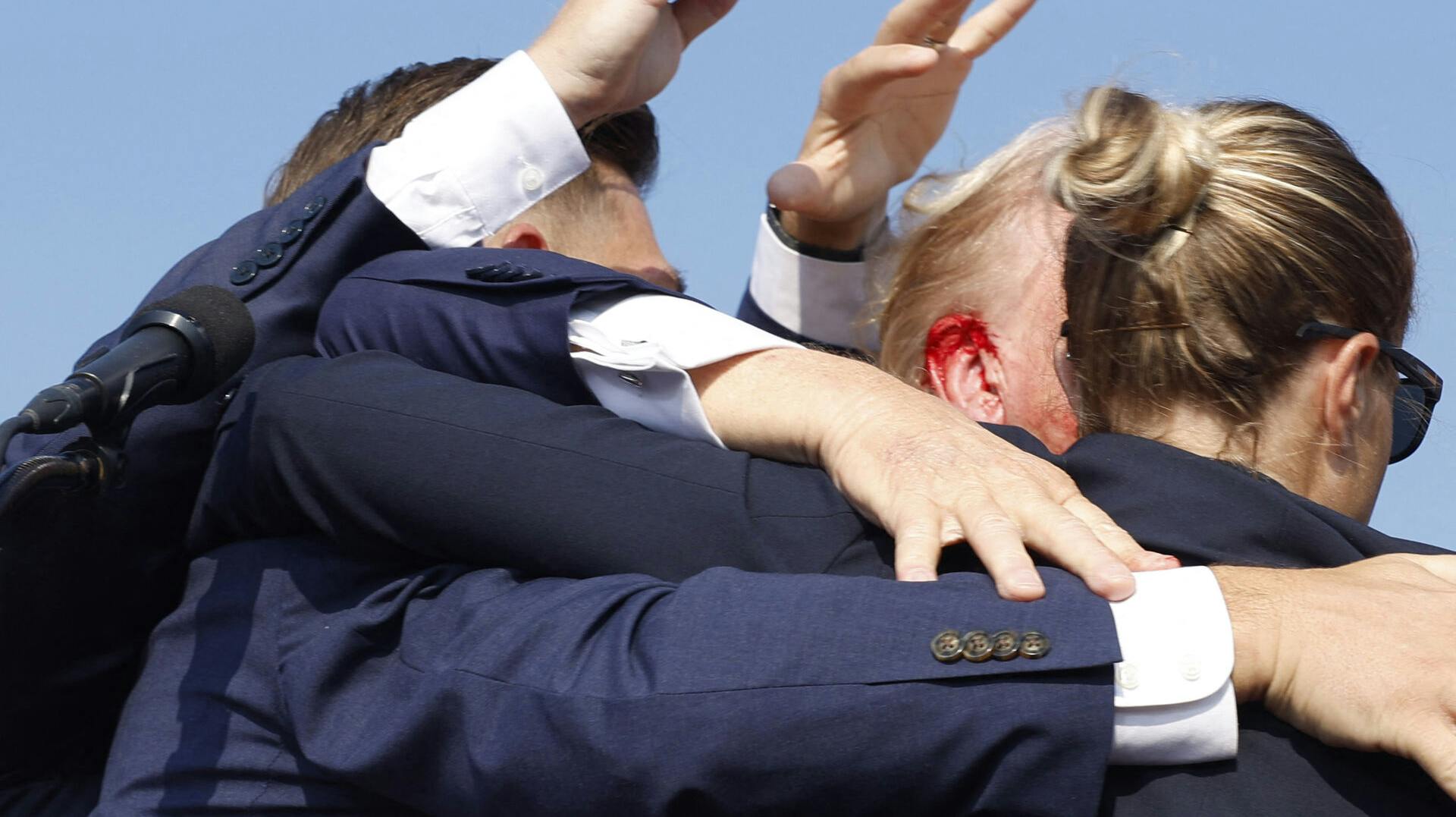 Donald Trump føres her bort af sine sikkerhedsfolk, hvor man tydeligt kan se, at han er blevet skadet i øret.