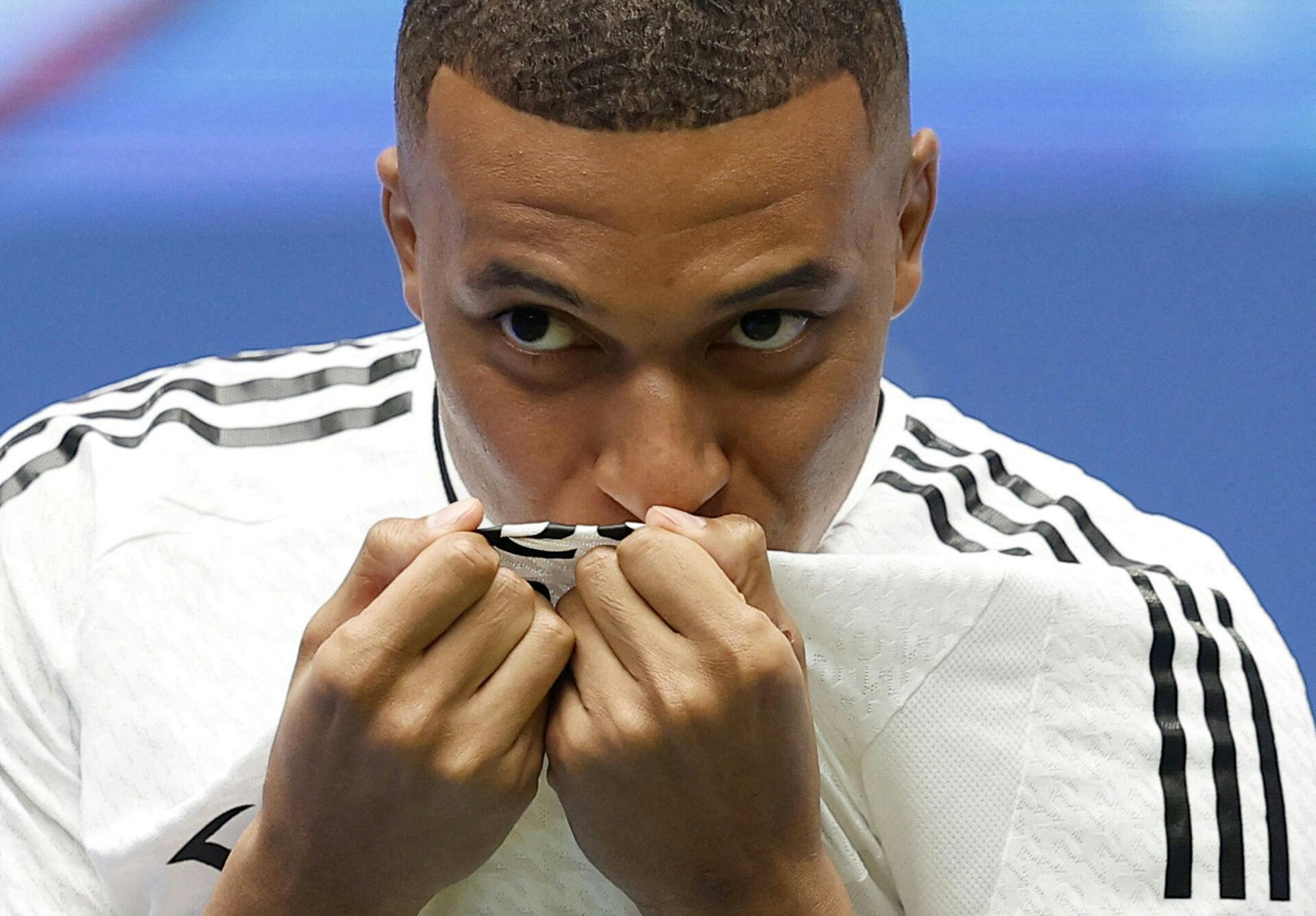 Kylian Mbappe kysser logoet på trøjen i hans nye klub Real Madrid.