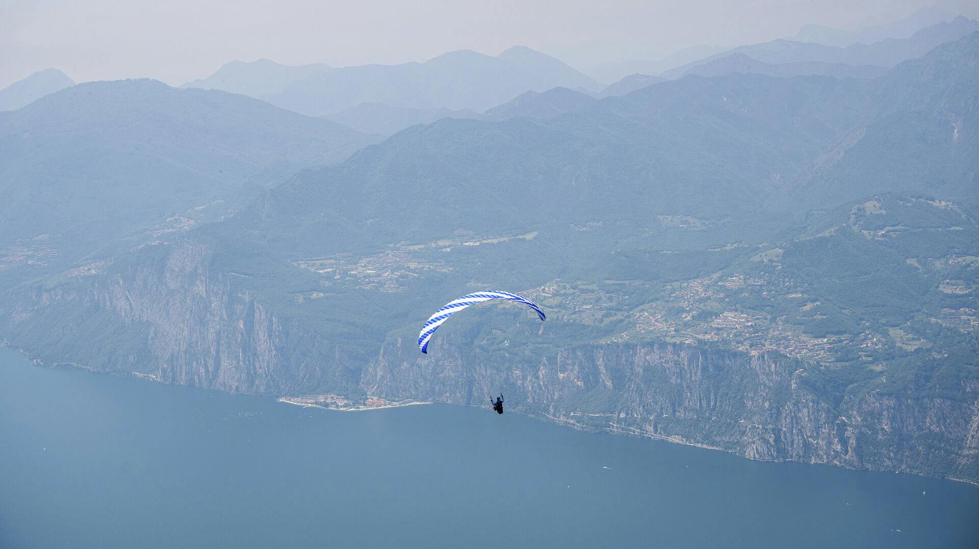 15 June 2021, Italy, Malcesine: View from the mountain Monte Baldo to the Lake Garda, above the water a paraglider is flying. Photo by: Daniel Reinhardt/picture-alliance/dpa/AP Images