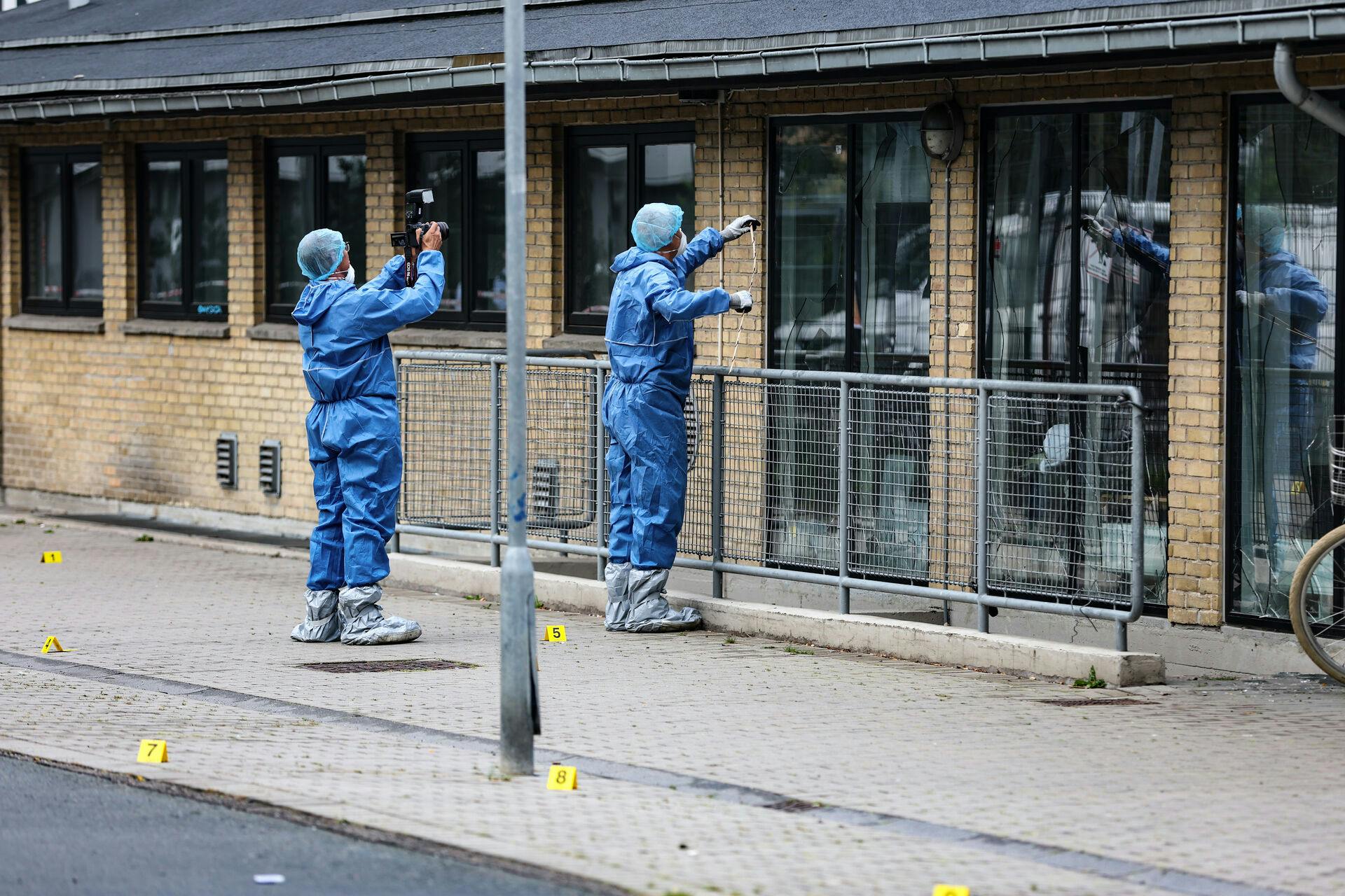 Politiet og deres kriminalteknikere arbejder ved den bygning, hvor den formodede håndgranat blev affyret.