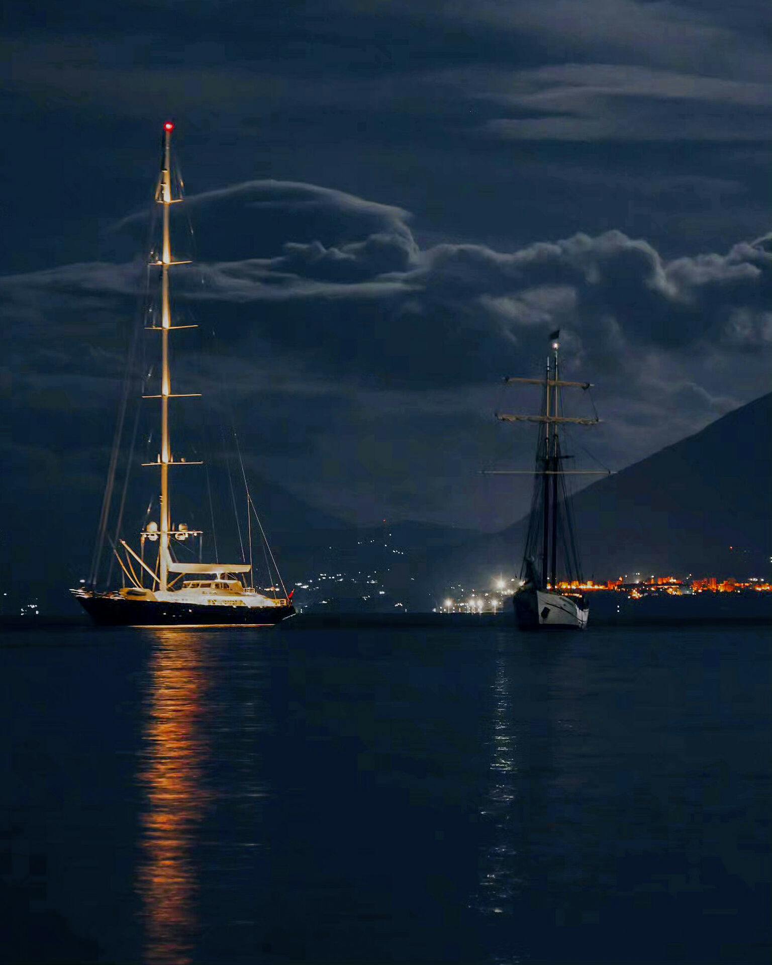 This picture taken at around 20.00gmt on Sunday, Aug. 18, 2024, shows the UK's vessel Bayesan, left, and the Duch sailboat Sir Robert Baden Powell at anchor off the Sicilian village of Porticello near Palermo, in southern Italy, The Bayesan sunk at around 02.00gmt when a violent sudden storm hit the area. 15 people where initially rescued by the crew of the Sir Robert Baden Powell. (Fabio La Bianca/Baia Santa Nicolicchia via AP)