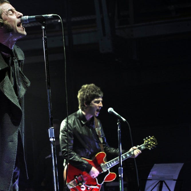 Brødrene Liam (t.v.) og Noel Gallagher (t.h.) ses her under en Oasis-koncert i München i Tyskland i august 2009. Senere samme år gik det legendariske band i opløsning på grund af en langvarig strid mellem de to frontfigurer. -