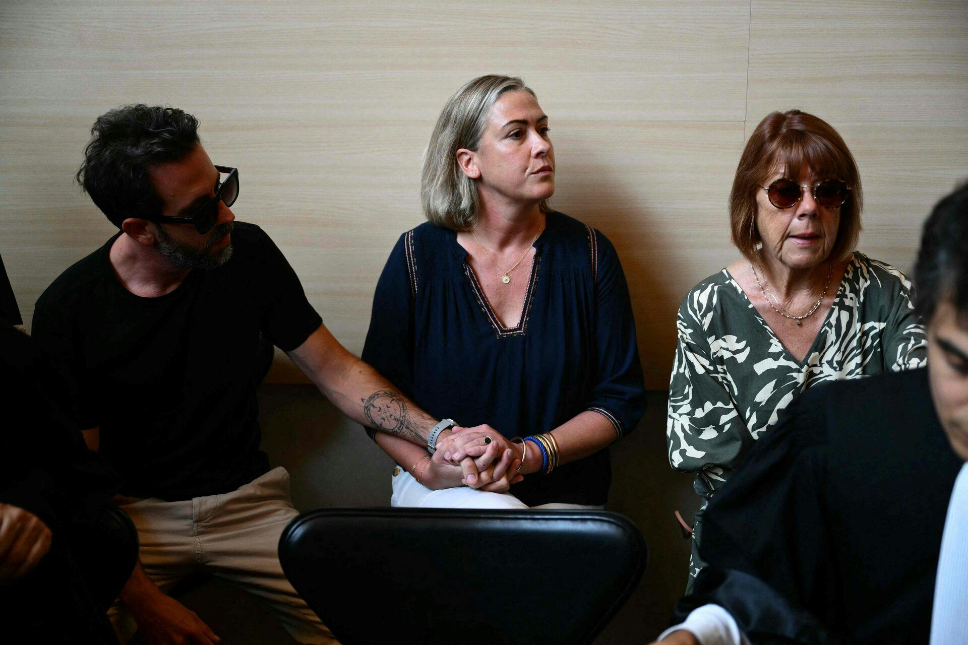 Gisele P. (R) sits beside her daughter Caroline Darian (C) and her son (L) at the courthouse during the trial of her husband accused of drugging her for nearly ten years and inviting strangers to rape her at their home in Mazan, a small town in the south of France, in Avignon, on September 2, 2024. The case involves 50 co-defendants. The defendants, 18 of whom are on remand, are men aged between 21 and 68 at the time of the events. (Photo by Christophe SIMON / AFP)