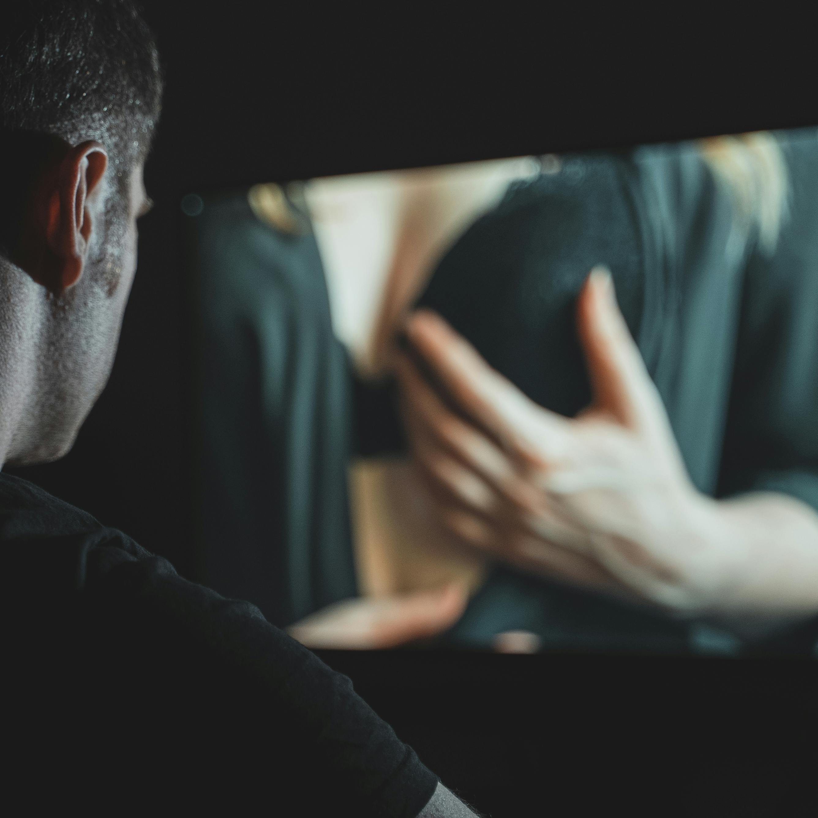 Man watching erotic film late at night.