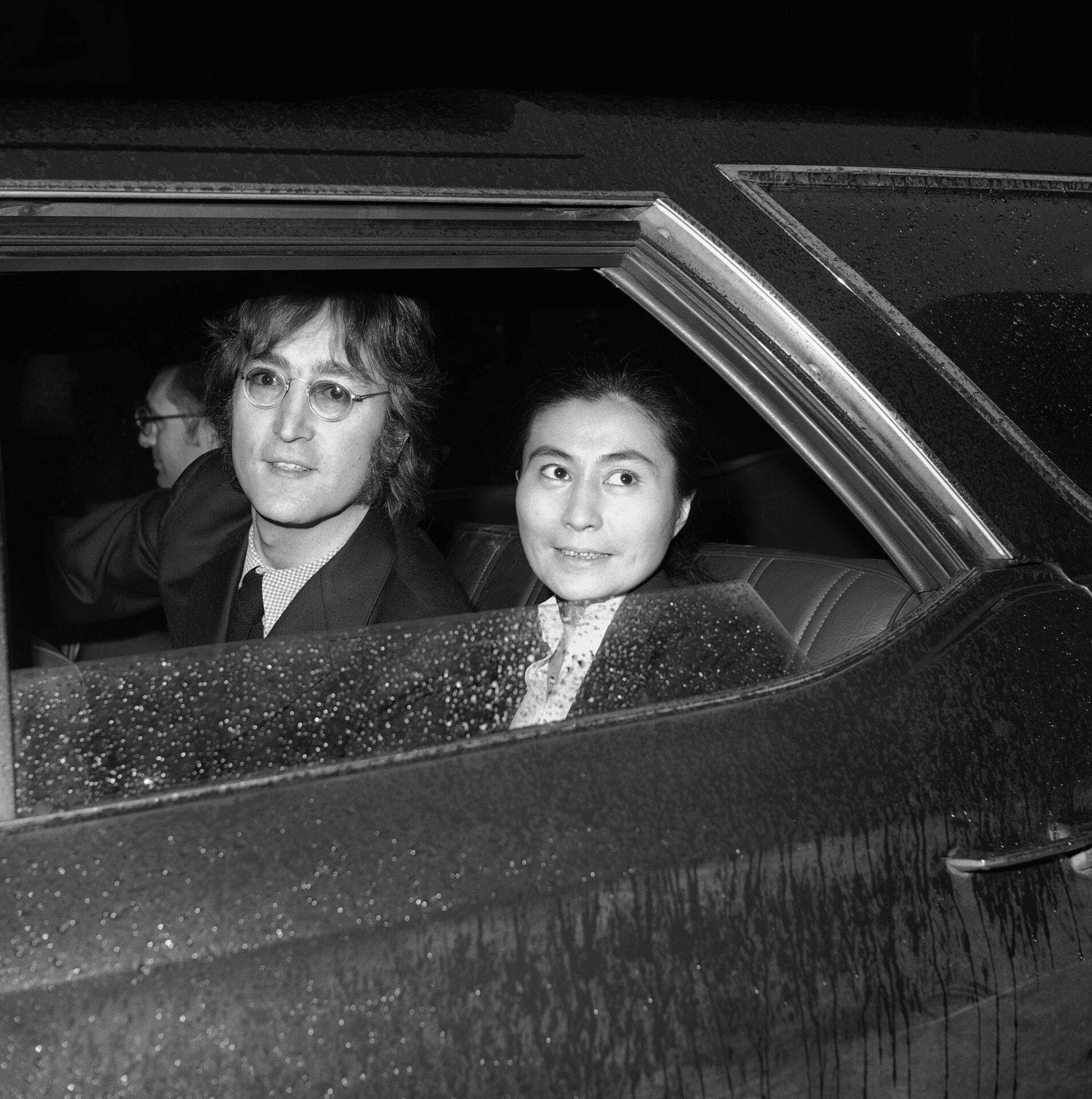 Former Beatle John Lennon, left, and his wife Yoko Ono, leave the Immigration and Naturalization Service, at 20 West Broadway, March 16, 1972, New York. His case was postponed and comes up in April (AP Photo/Anthony Camerano)