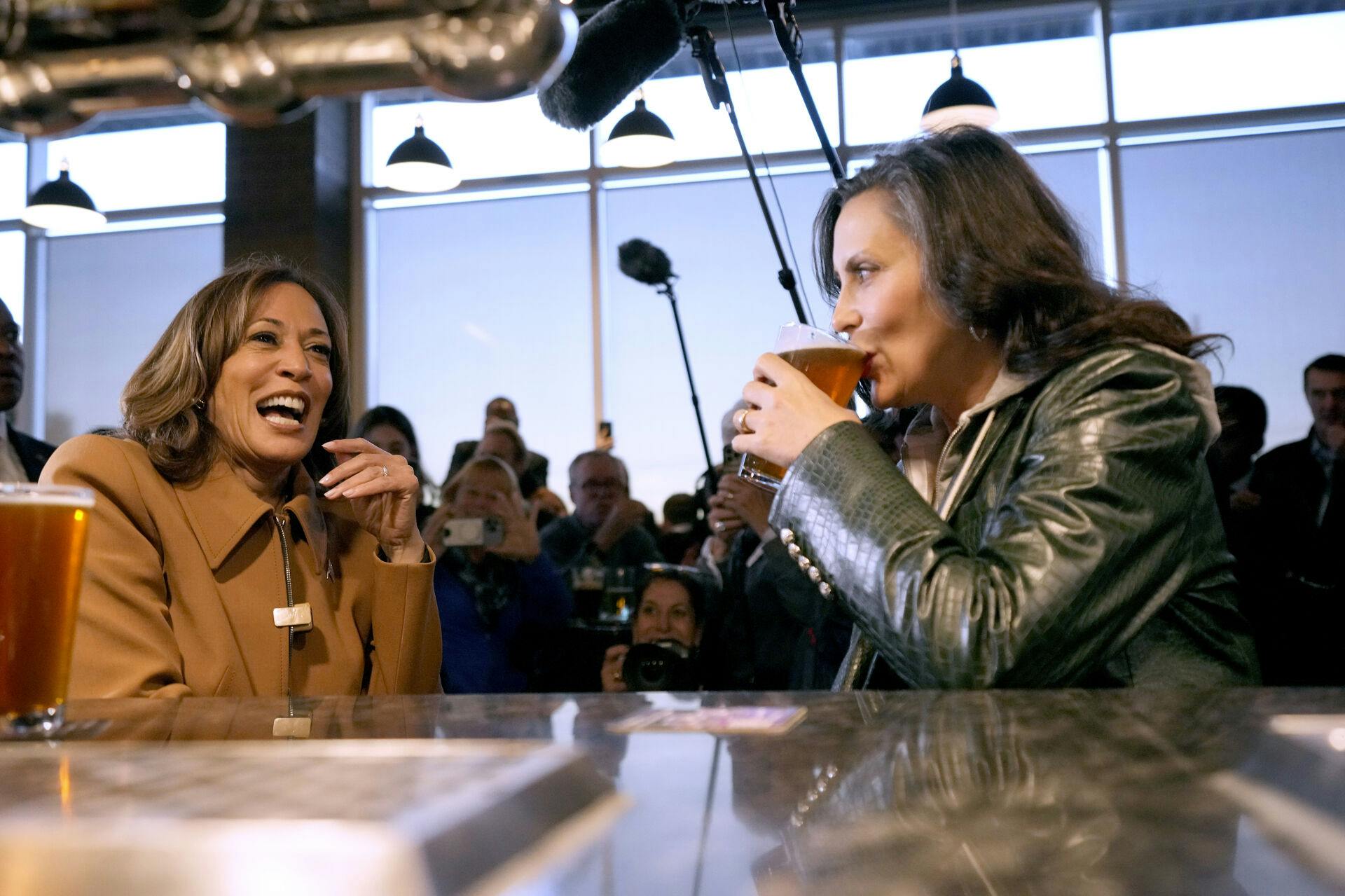 Democratic presidential nominee Vice President Kamala Harris, left, and Michigan Gov. Gretchen Whitmer drink beer at the Trak Houz Bar & Grill after a campaign rally in Kalamazoo, Mich. (AP Photo/Jacquelyn Martin)