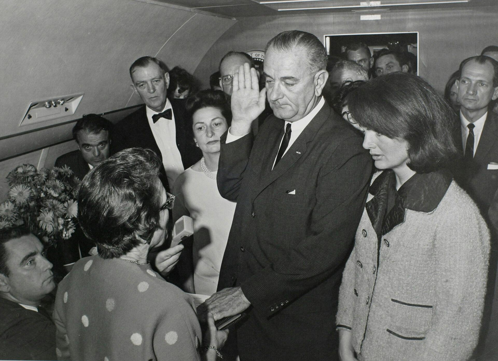 Lyndon B. Johnson ombord Air Force One. Jackie bærer stadig den blodstængte Chanel-frakke.