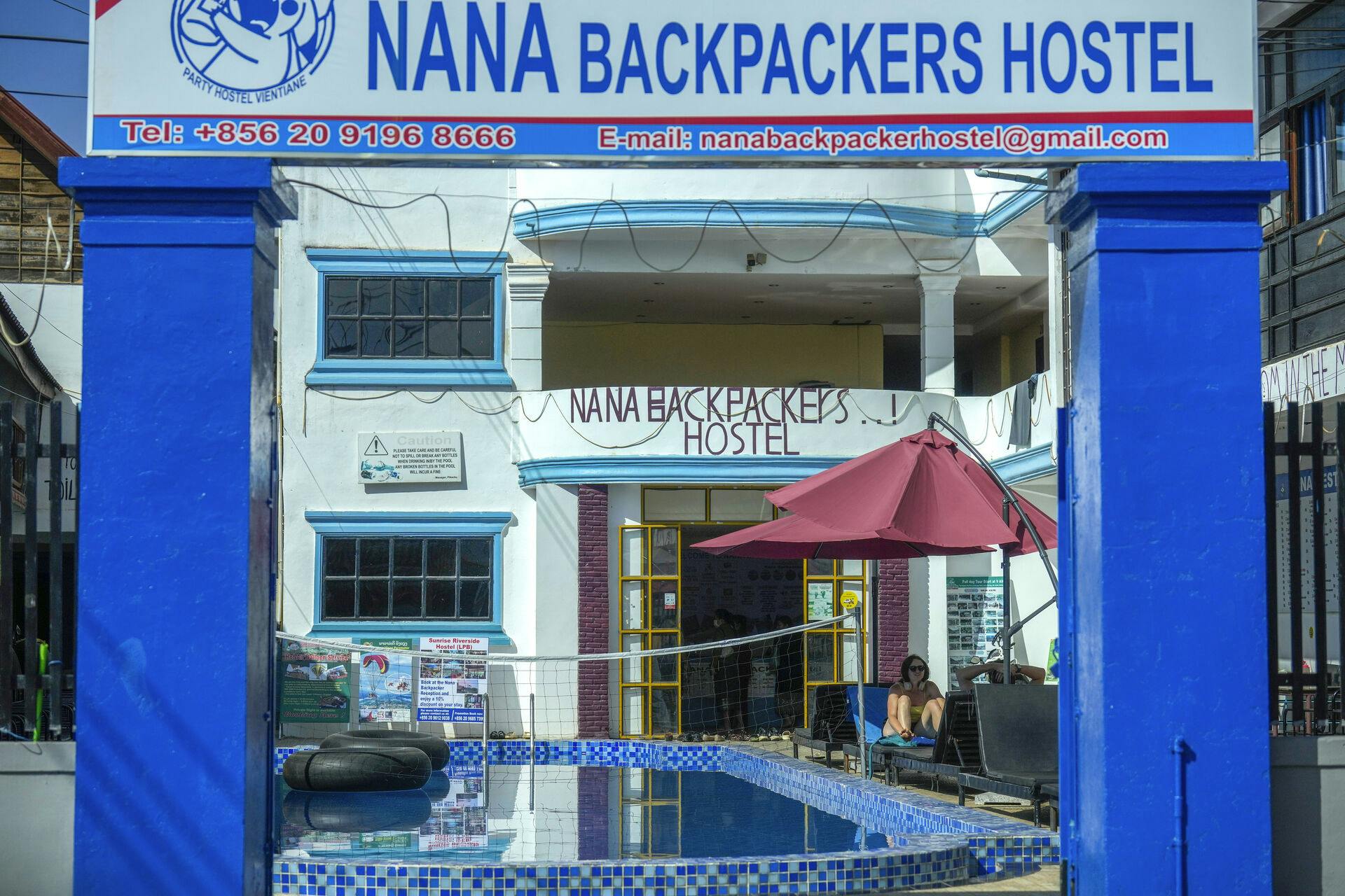 A foreign tourist couple rest near a swimming pool at Nana Backpackers hostel in Vang Vieng, Laos, Friday, Nov. 22, 2024. (AP Photo/Anupam Nath)