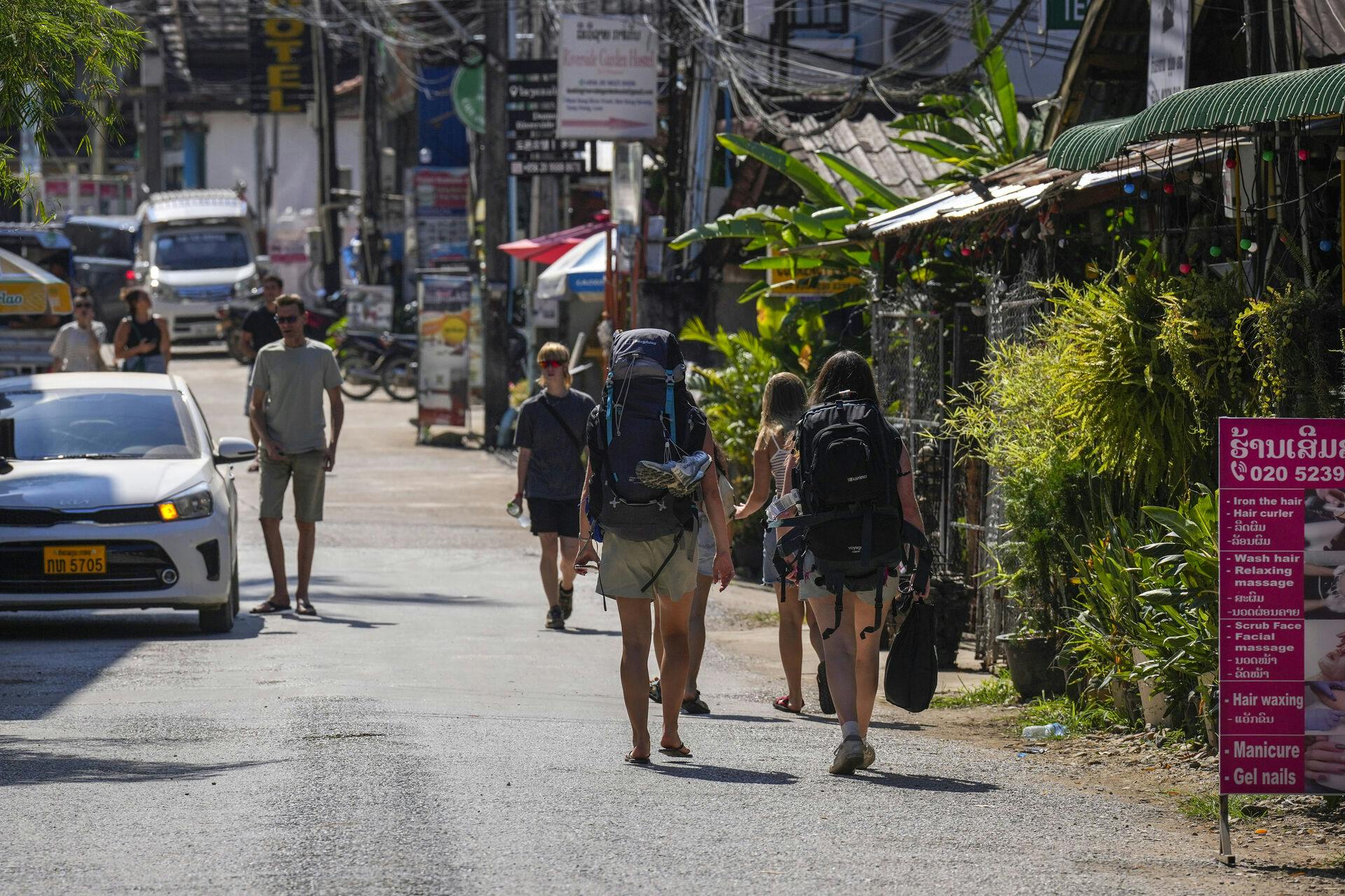 Backpacker foreign tourists roam around in Vang Vieng, Laos, Friday, Nov. 22, 2024. (AP Photo/Anupam Nath)