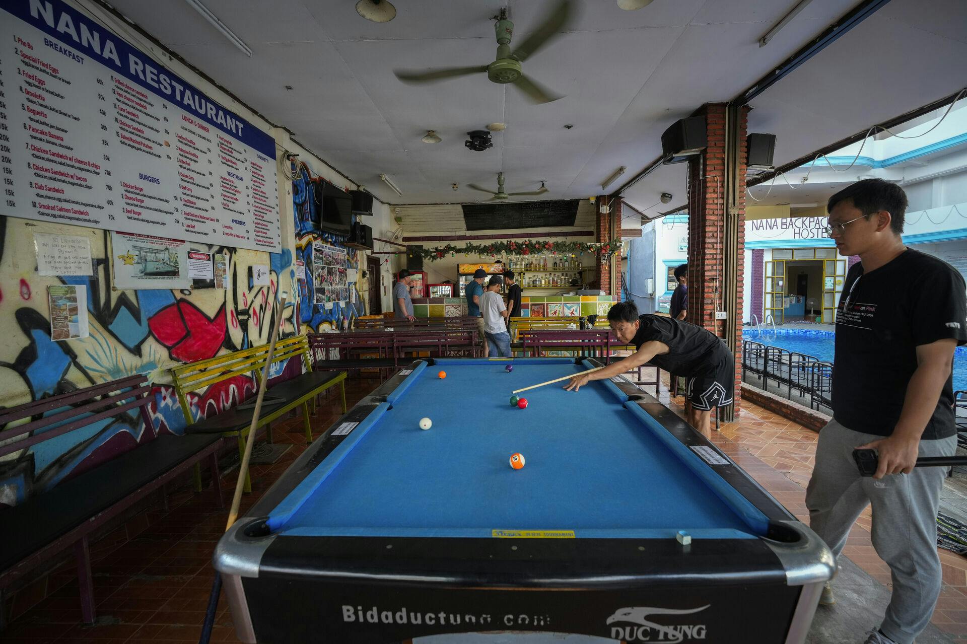 A man plays pool at Nana Backpack hostel in Vang Vieng, Laos, Tuesday, Nov. 19, 2024. (AP Photo/Anupam Nath)