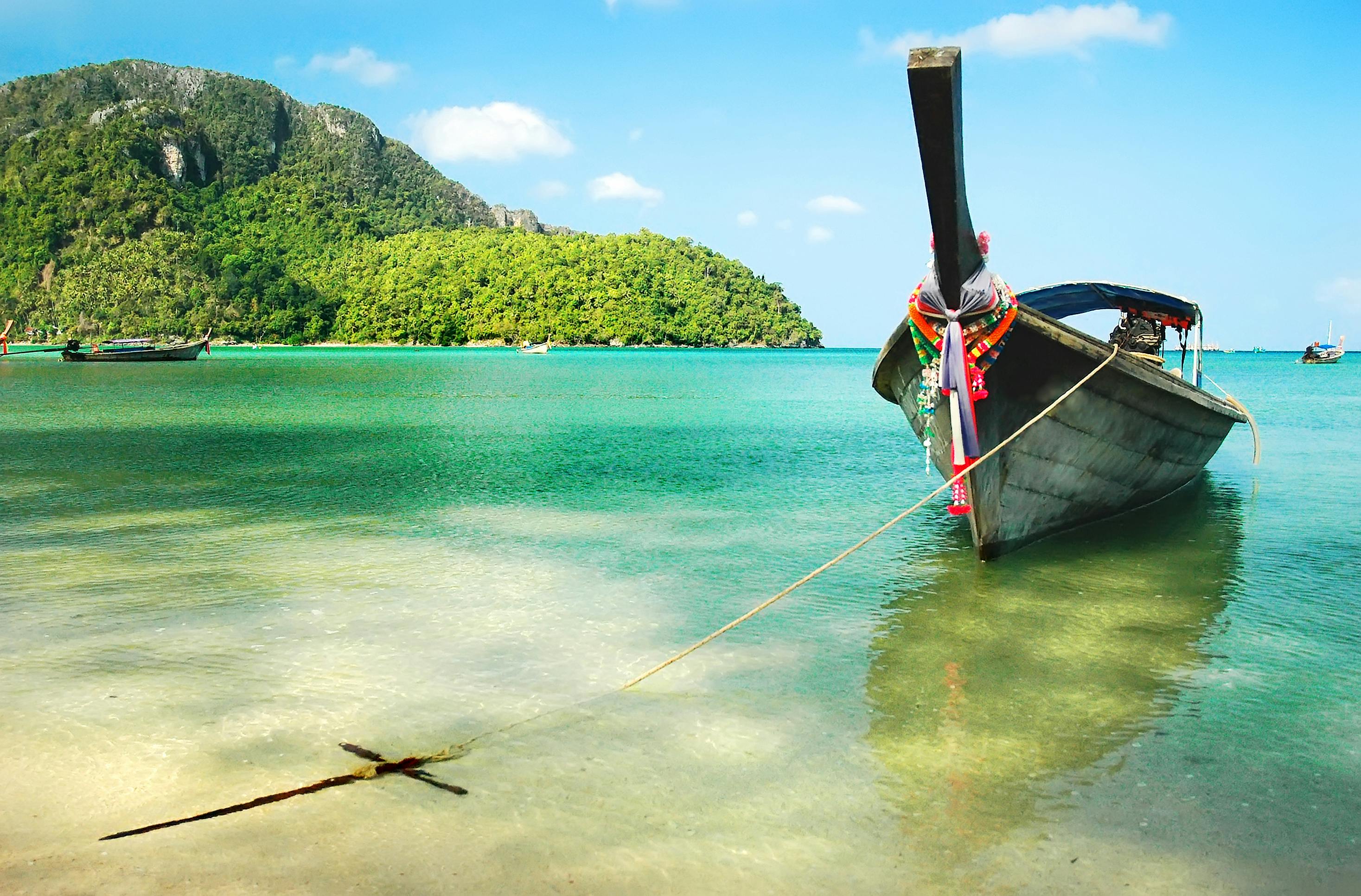 Wooden boat moored on the beach of the island of Phi Phi, Thailand