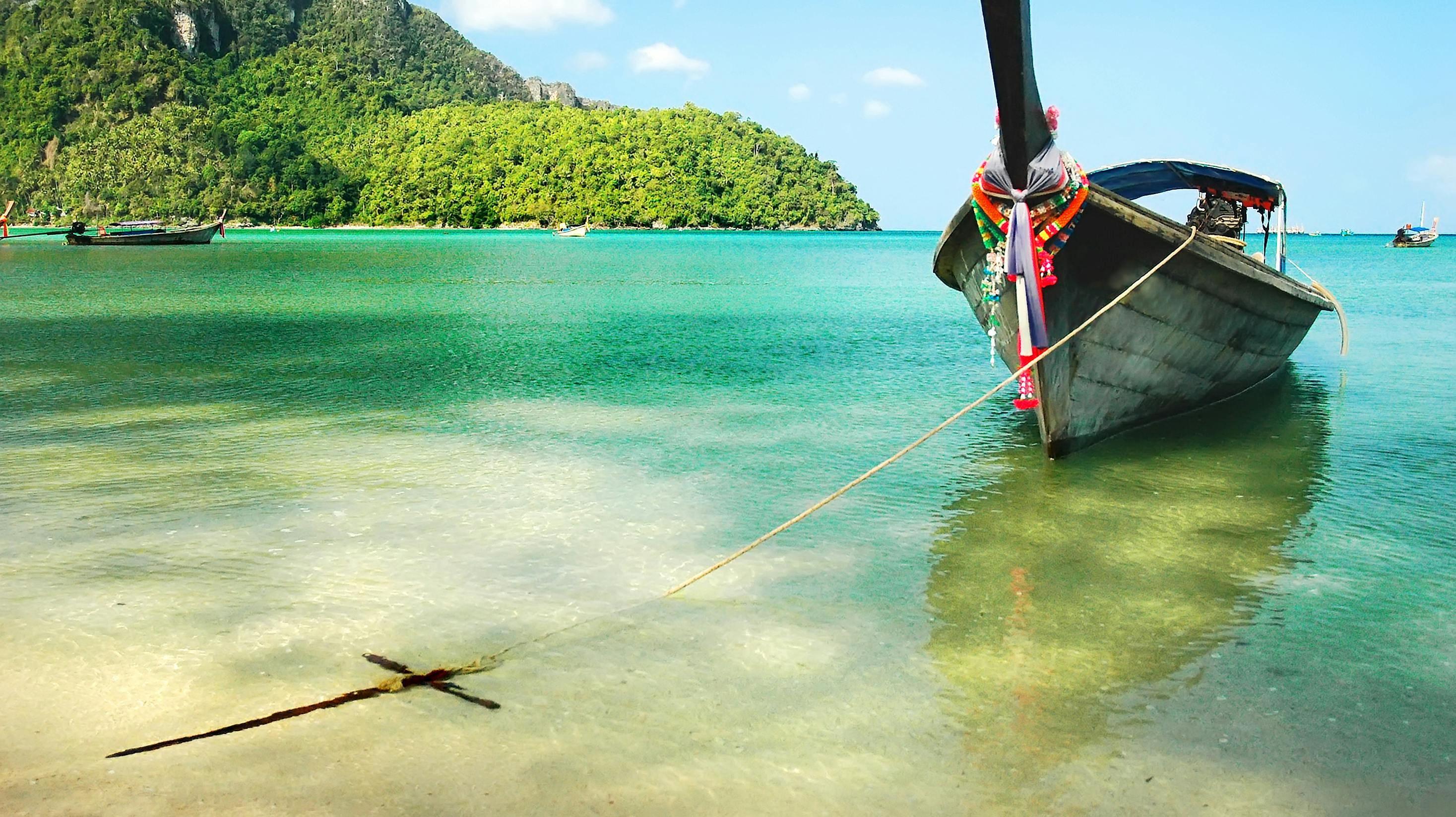 Wooden boat moored on the beach of the island of Phi Phi, Thailand