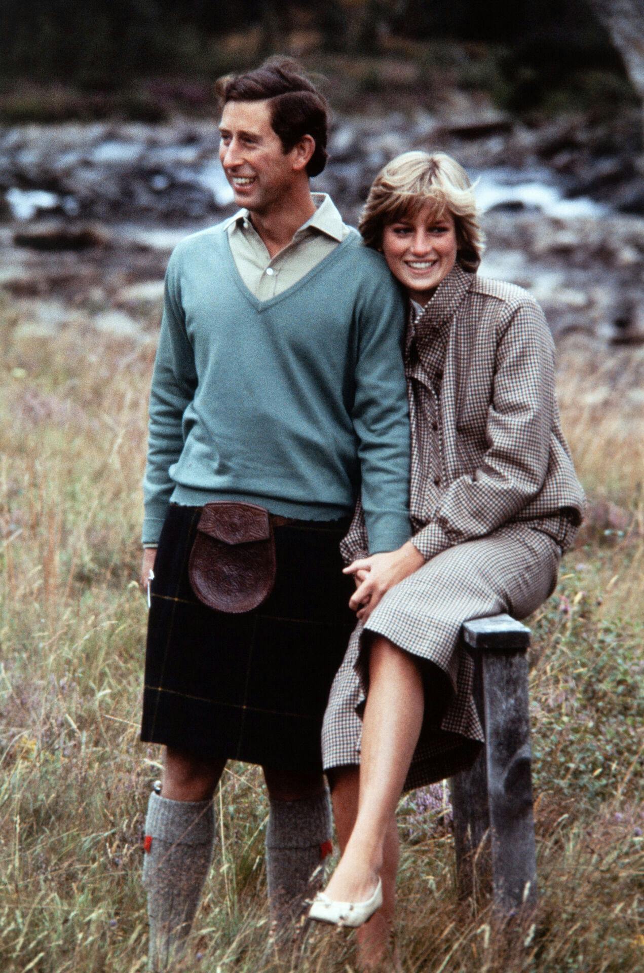 Prince Charles, Prince of Wales, wearing a kilt, and Diana, Princess of Wales, pose for photographers beside the River Dee in Scotland during their post-honeymoon visit to the Royal Residence at Balmoral Castle, on August 19, 1981. POOL / AFP