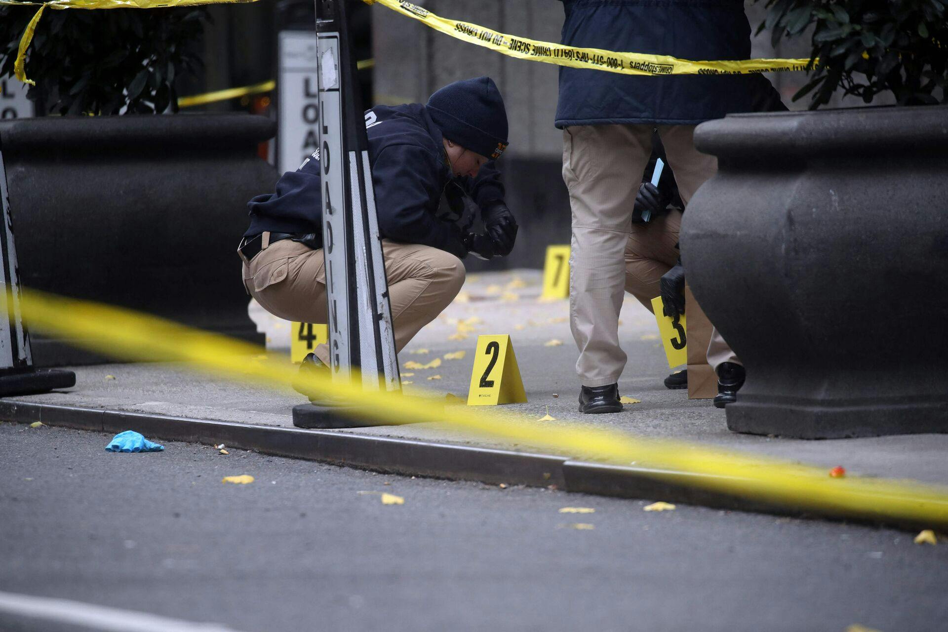NEW YORK, NEW YORK - DECEMBER 04: Police place bullet casing markers outside of a Hilton Hotel in Midtown Manhattan where United Healthcare CEO Brian Thompson was fatally shot on December 04, 2024 in New York City. Brian Thompson was shot and killed before 7:00 AM this morning outside the Hilton Hotel, just before he was set to attend the company's annual investors' meeting. Spencer Platt/Getty Images/AFP (Photo by SPENCER PLATT / GETTY IMAGES NORTH AMERICA / Getty Images via AFP)