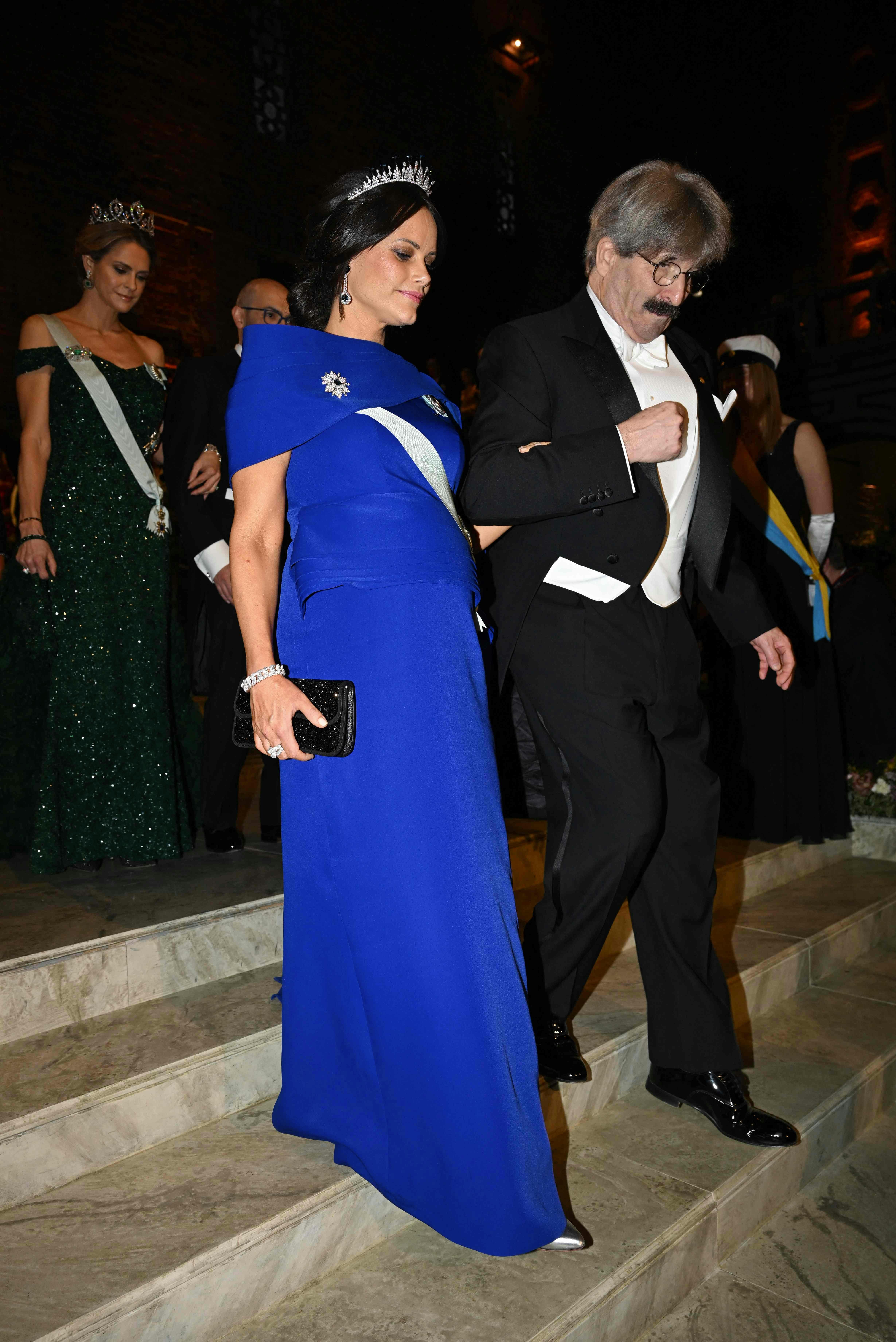 Nobel Prize in Physiology or Medicine 2024 laureate and US molecular biologist Gary Ruvkun (R) arrives with Princess Sofia of Sweden for the Nobel Prize banquet at the City Hall in Stockholm, Sweden on December 10, 2024. (Photo by Jonathan NACKSTRAND / AFP)